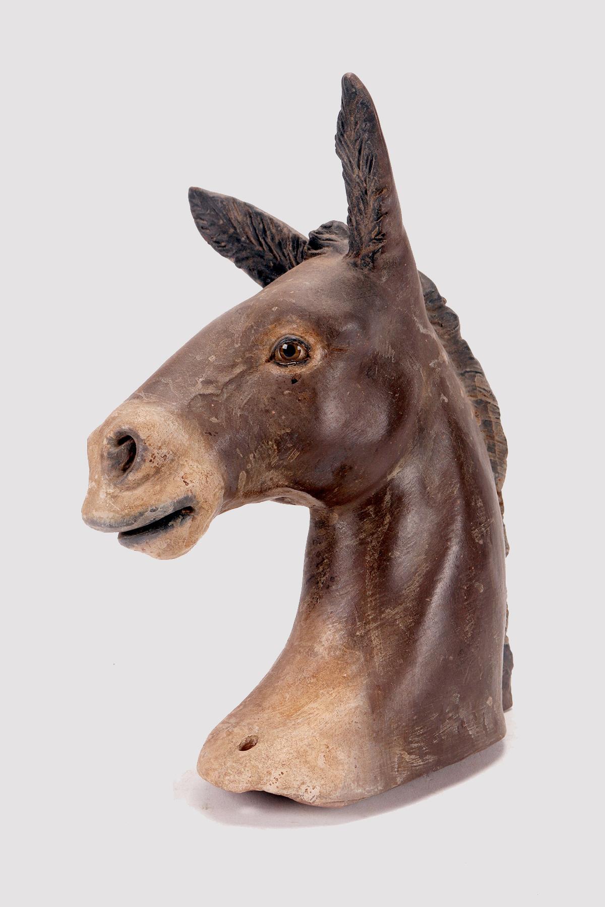 Terracotta nativity sculpture depicting the neck and head of a donkey. The sculpture is made of terracotta entirely by hand, finished in stick and color. In the nativity scene, the donkey is ideally placed to the left of the child. Remarkable