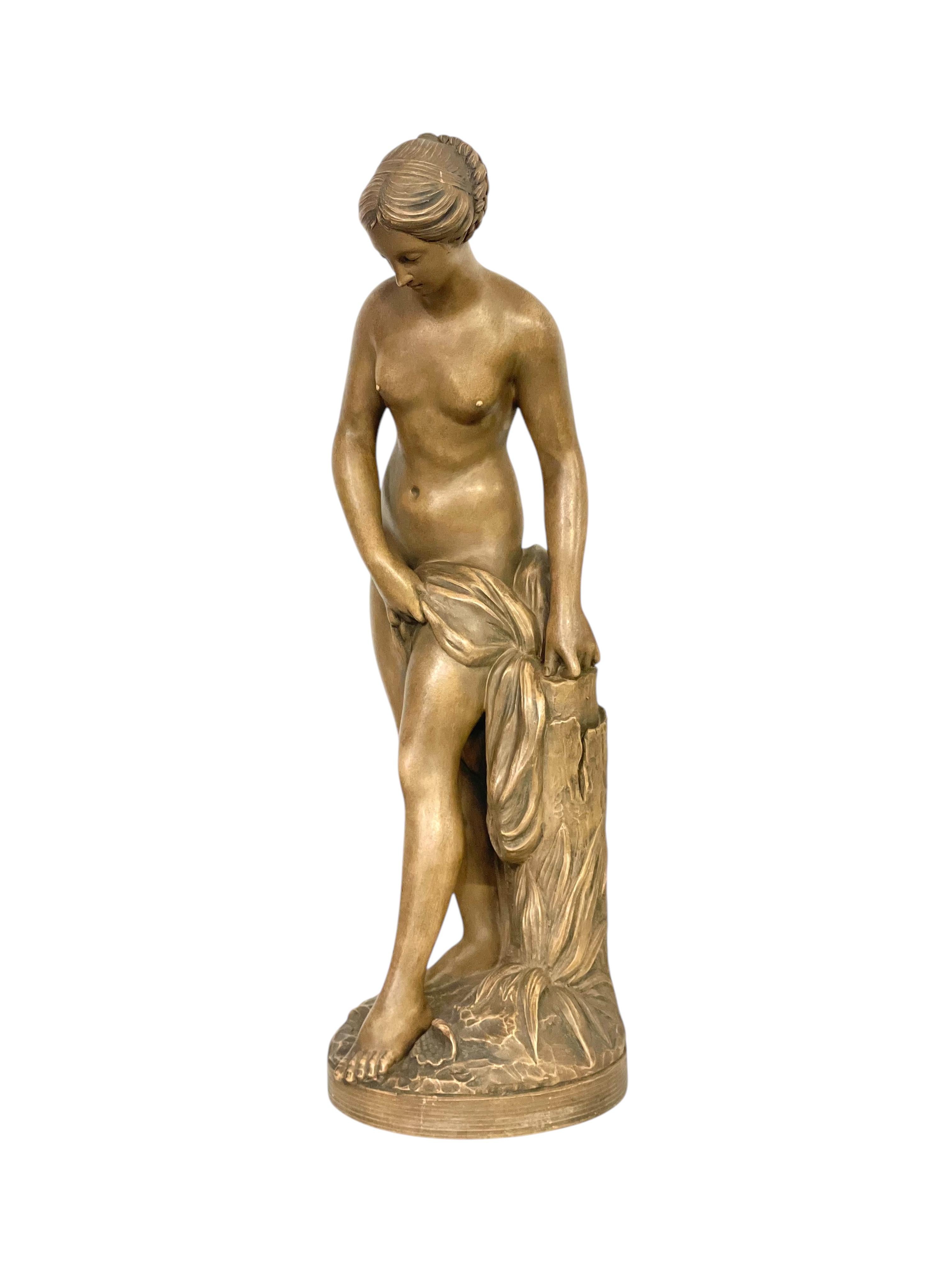 Questa elegante scultura in terracotta è una raffinata interpretazione di un nudo femminile classico, ispirata al celebre scultore francese del XVIII secolo Étienne-Maurice Falconet. L'opera raffigura una graziosa giovane donna in piedi in una dolce