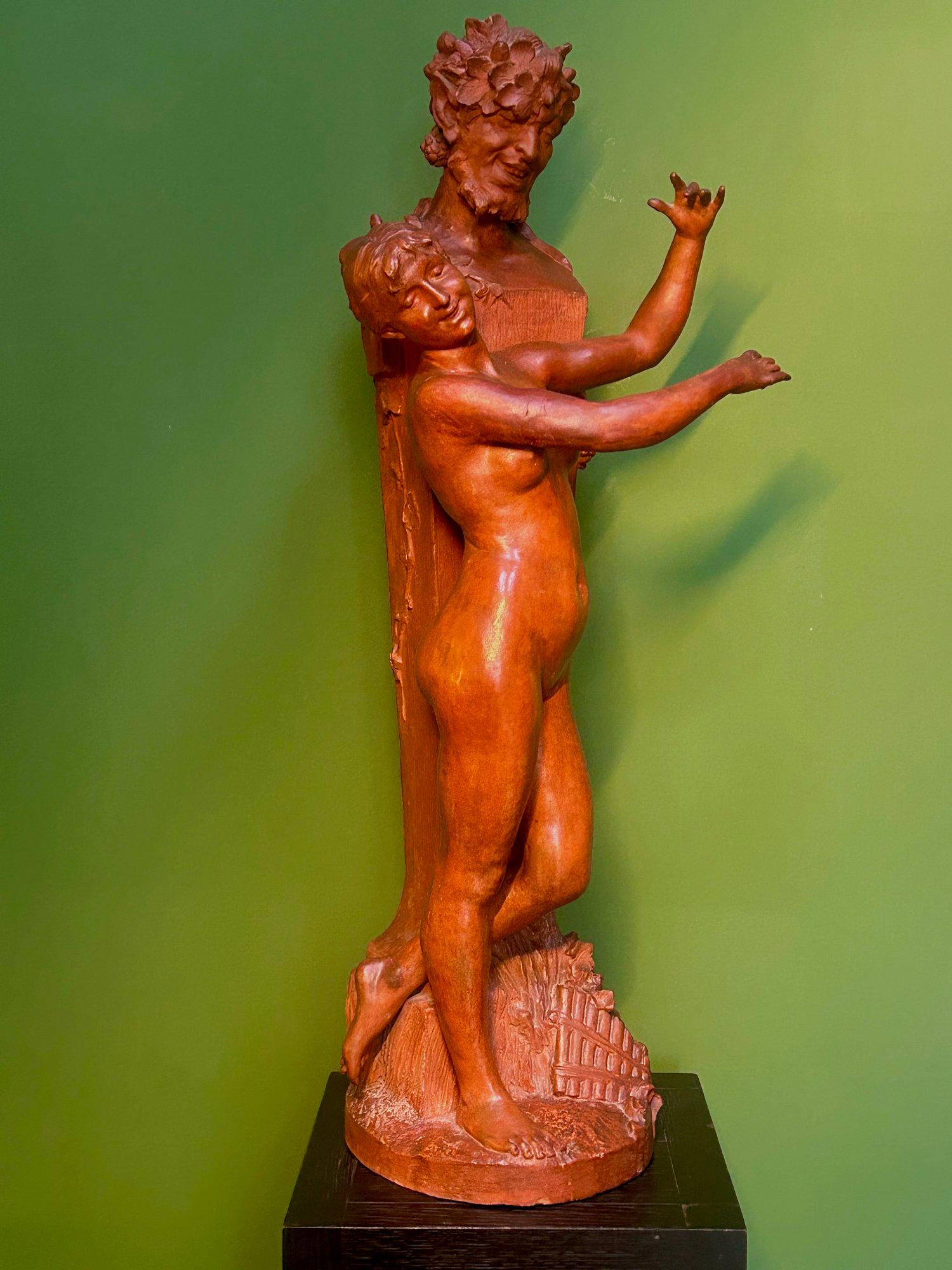 Scultura in terracotta di Ninfa e Dio Pan, Scultura in terracotta di Ninfa e Satiro, Scultura di Ninfa e Fauno, Statua di Ninfa e Satiro. 

Grande scultura in terracotta di 93 cm raffigurante Ninfa davanti al Dio Pan (Satiro), firmata e datata 1905