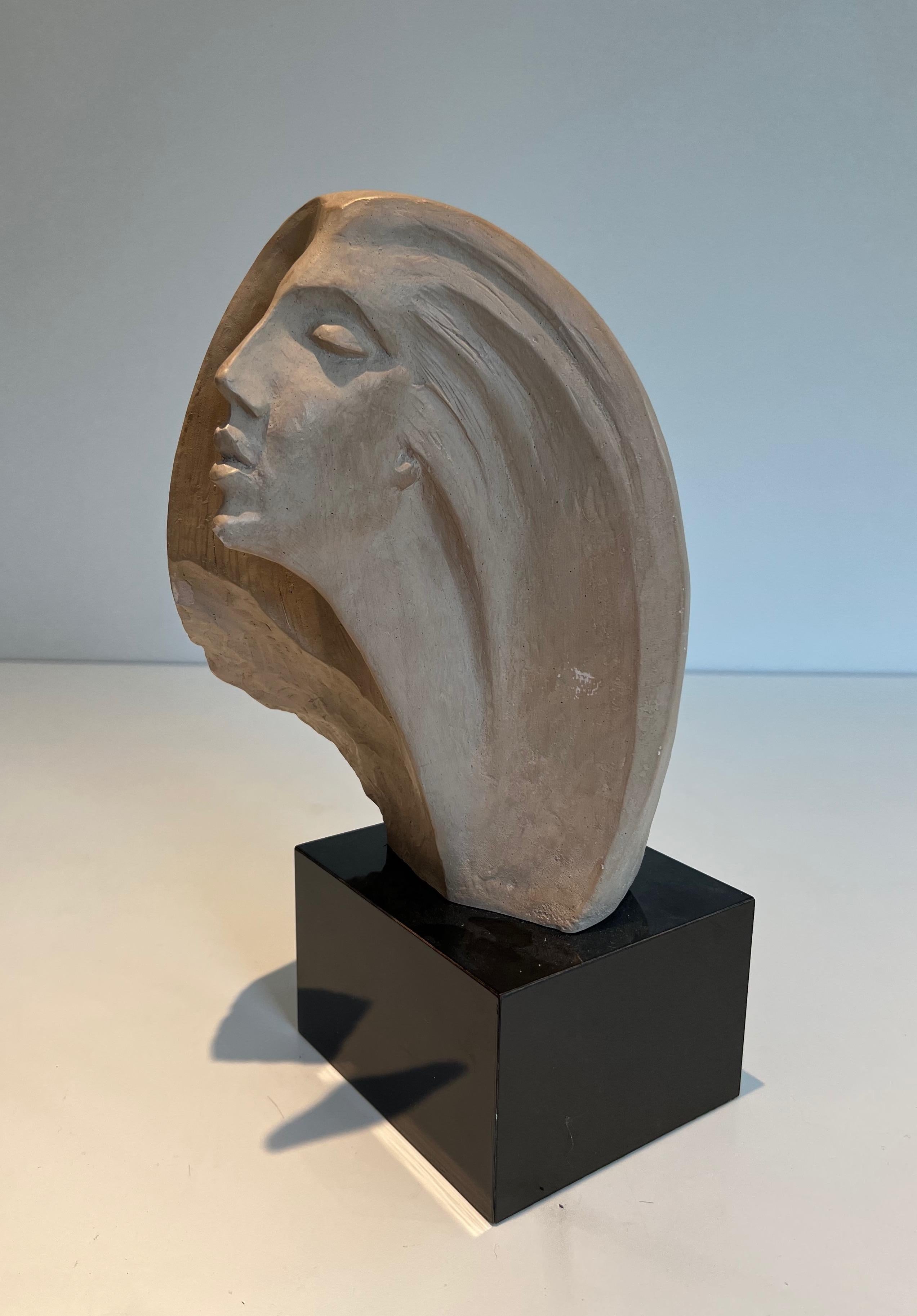 This nice sculpture representing a woman's face is made of terracotta on a square blackened wood base (slight shine on the chin and hair). Work signed by Austin Prod. 1980