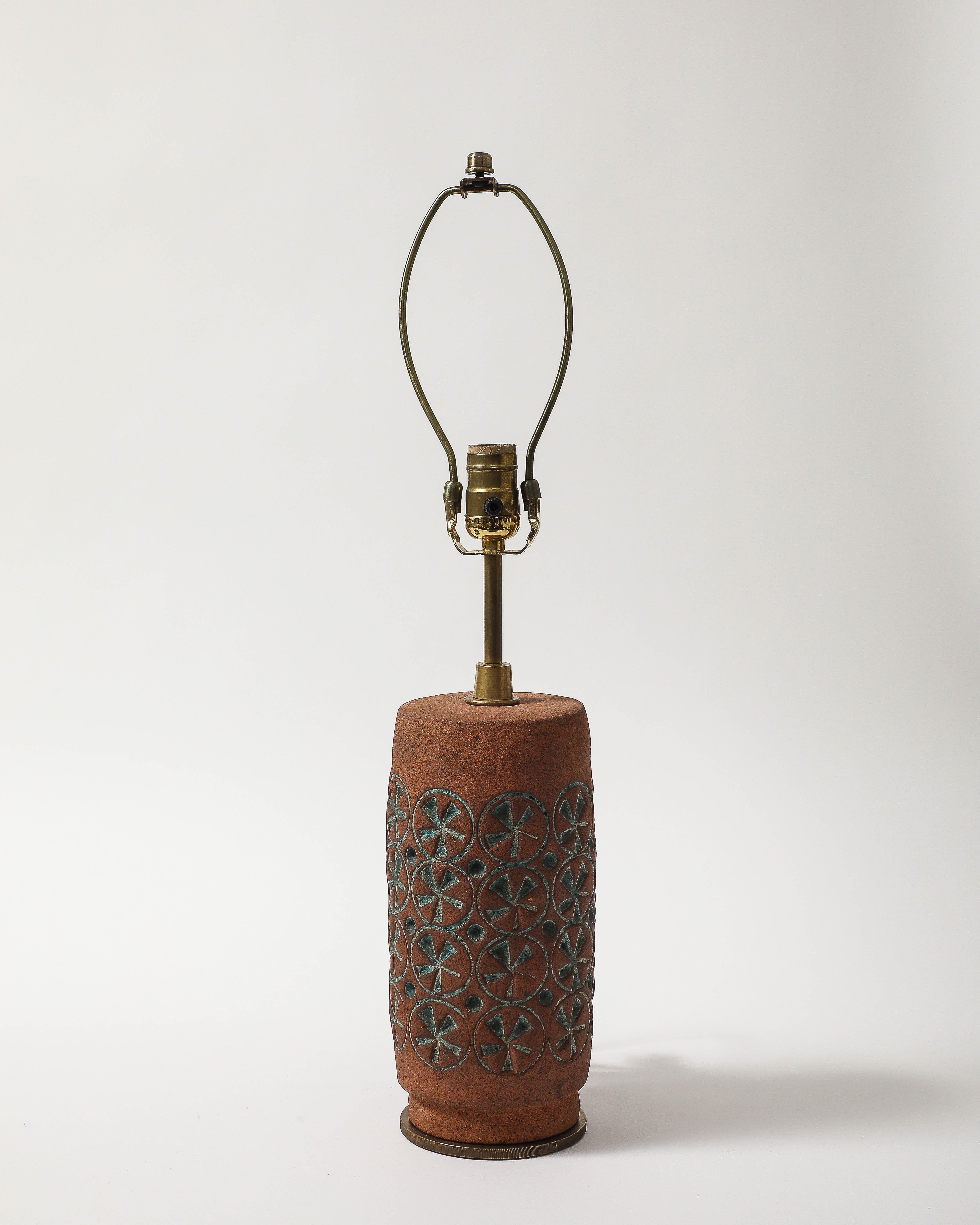 Lampe de table en terre cuite présentant un laganidé émaillé sarcelle et un motif de cercle autour du corps. Cette pièce a été récemment recâblée avec un bouton de gradation au niveau du col et dispose d'une base en bronze pour la stabilité.