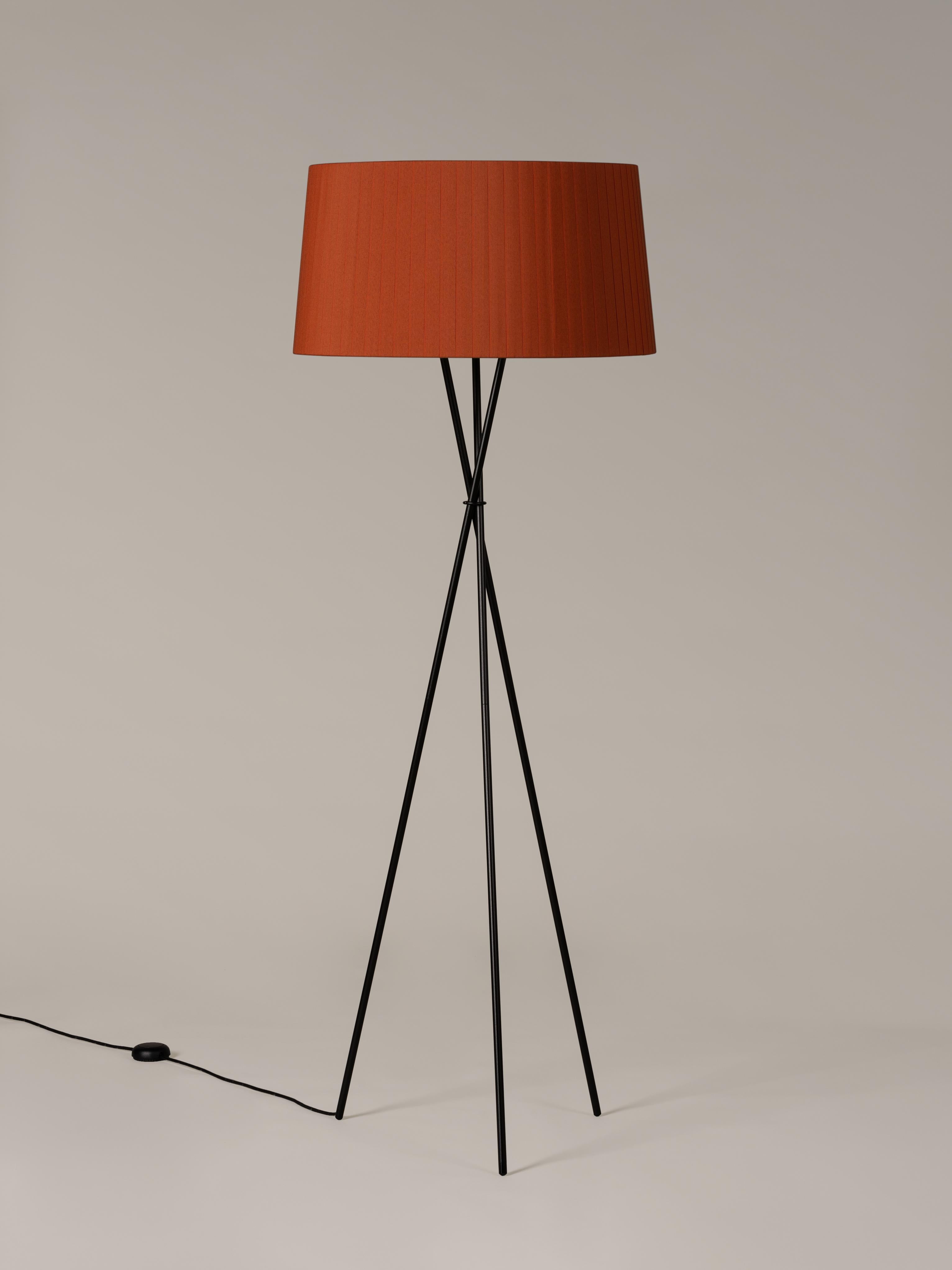 Terracotta Trípode G5 floor lamp by Santa & Cole
Dimensions: D 62 x H 168 cm
Materials: Metal, ribbon.
Available in other colors.

Trípode humanises neutral spaces with its colourful and functional sobriety. The shade is hand ribboned and its