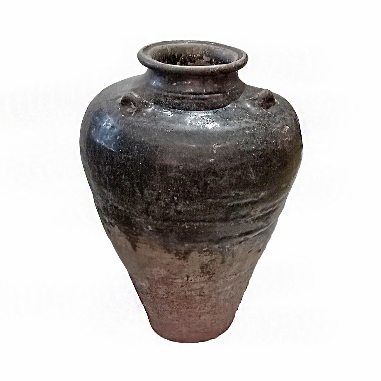 A large terracotta jar / vase / urn from Bali, Indonesia, late 20th Century, hand-crafted. Decorative handles and semi-gloss black glaze. Narrow top and bottom. 

Can be used indoors or outdoors. 
