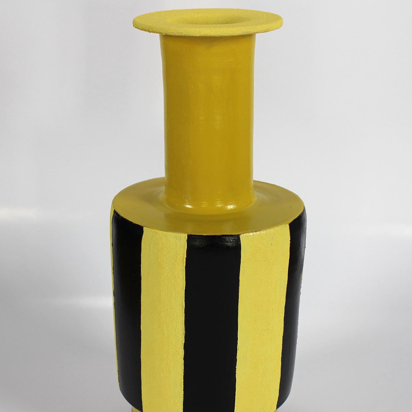 This eye-catching vase by Italian designer Mascia Meccani is crafted from red terracotta. Hand painted using a mixture of artisanal techniques in statement yellow and black tones, the design is distinguished by a robust silhouette with a tall neck