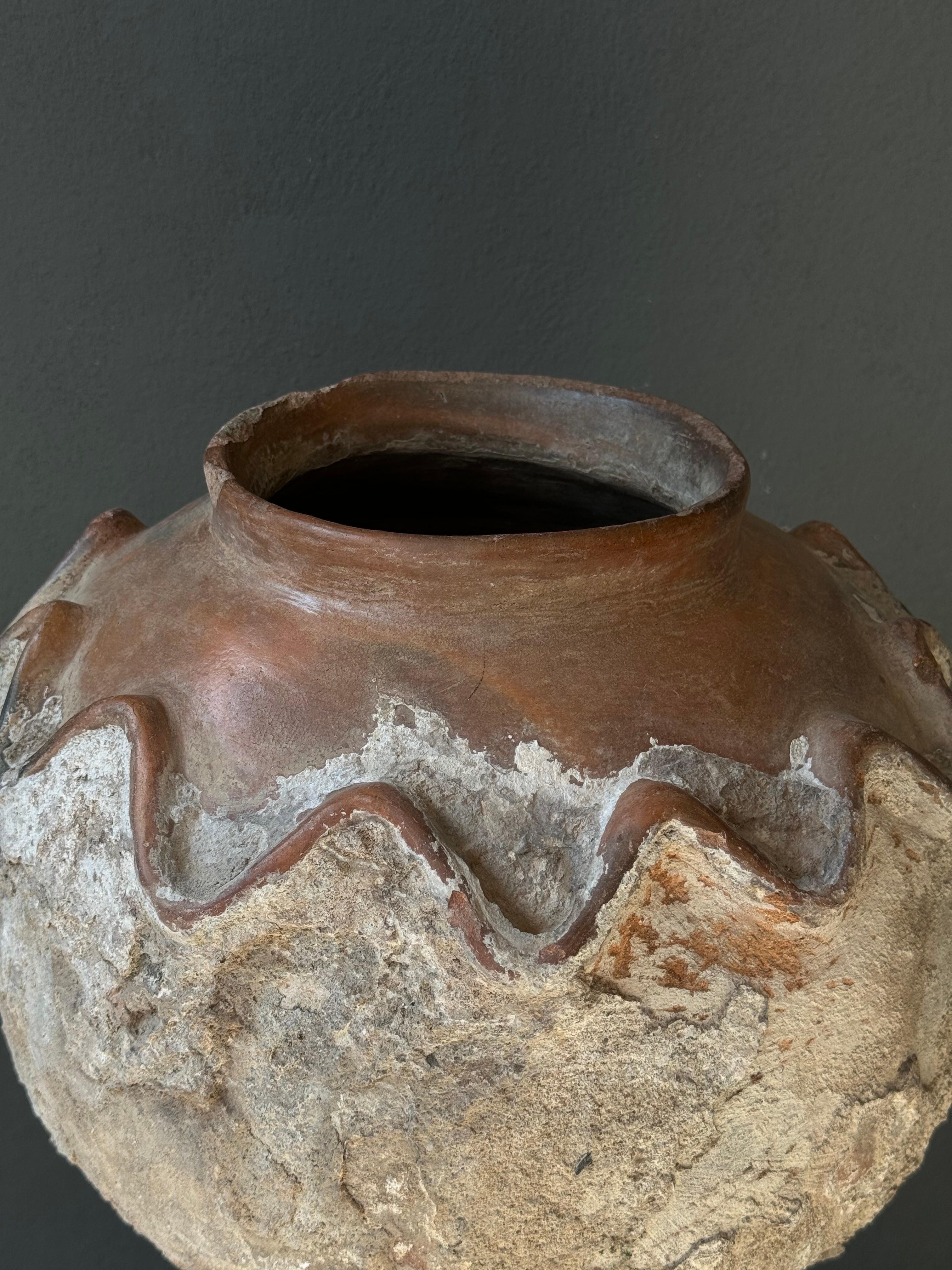 Terracotta water vessel from Central Michoacan, Mexico, early 20th century. The bottom half of the pot has been covered in cement for protection and cooling purposes. The zig zag design stems from the Purepecha indigenous culture. Each of these