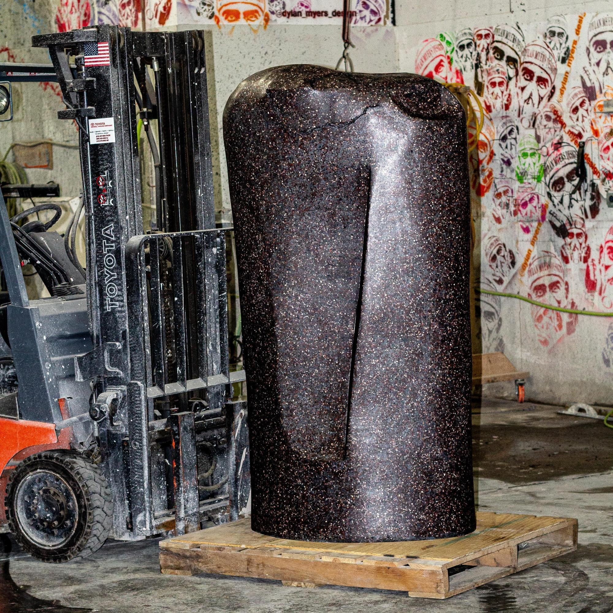 Anomaly ONE ist ein 6 Fuß hohes skulpturales Totem aus der Serie Concrete Anomaly - gegossen aus GFK-Beton und poliertem schwarzen Terrazzo. In die Oberfläche sind Mineralien eingebettet, die unter der soliden, monolithischen Form eine subtile