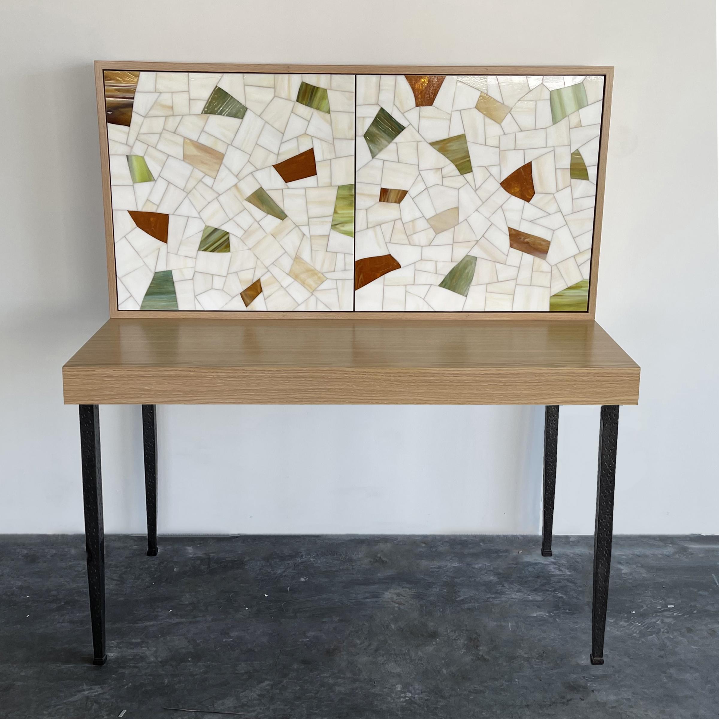 The terrazzo desk by Ercole Home is a stationary desk with a 2 door touch latch storage cabinet above.
The doors are covered in our iconic Terrazzo pattern finish with an assortment of light ivories and terracotta glass
The wood finish on this