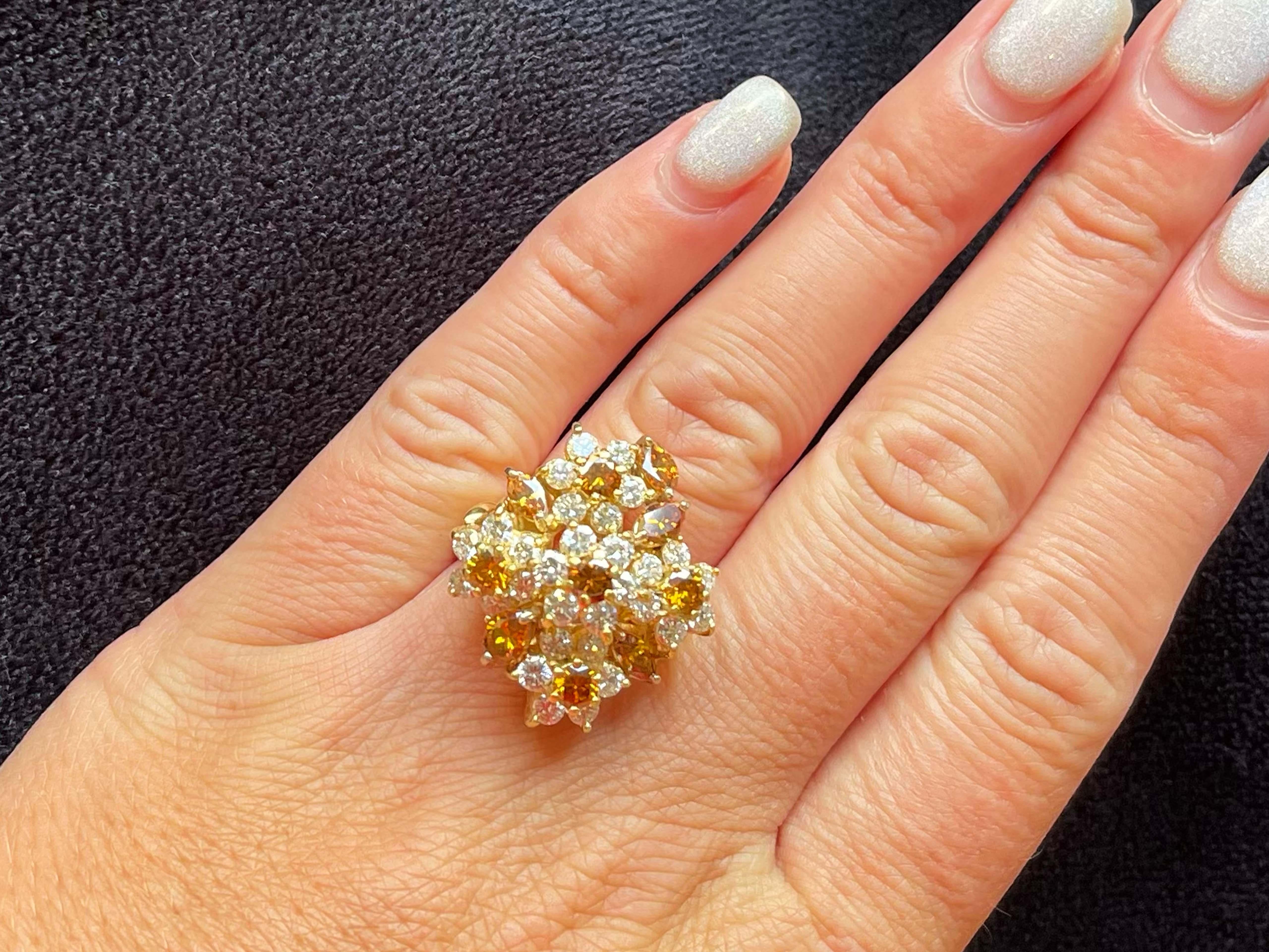 This magnificent floral bouquet of Diamonds designed by Terrel & Zimmelman is just stunning. The ring design features five flowers, each containing 6 round brilliant white diamonds with a natural vivid cognac orange diamond in the center, scattered