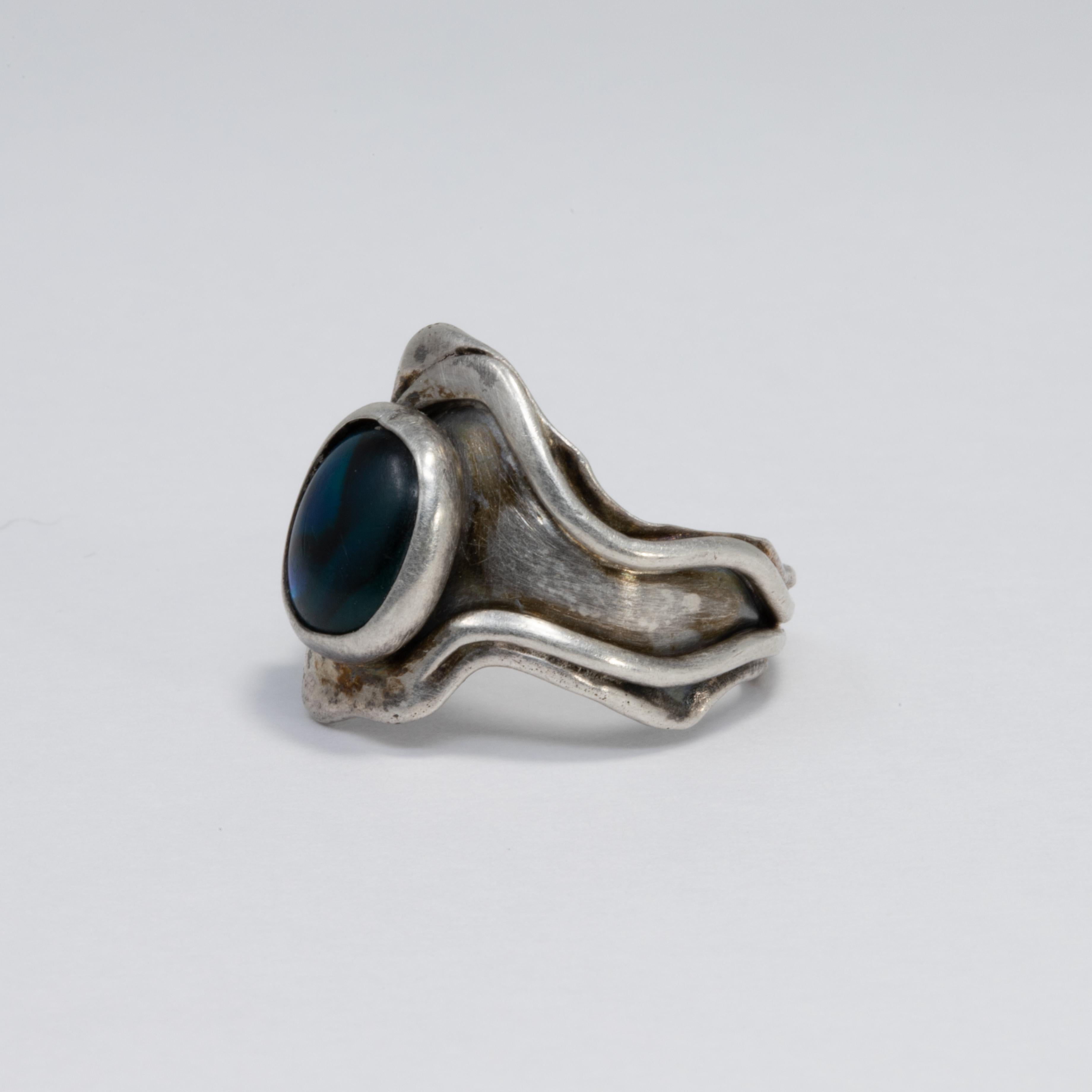 A gorgeous Native American sterling silver ring, with a mesmerizing blue and green gemstone centerpiece. Hand-made by skilled Zuni craftsmen.

Ring Size US 7

Statement/cocktail style.

Marks / hallmarks / etc: TJM, STER