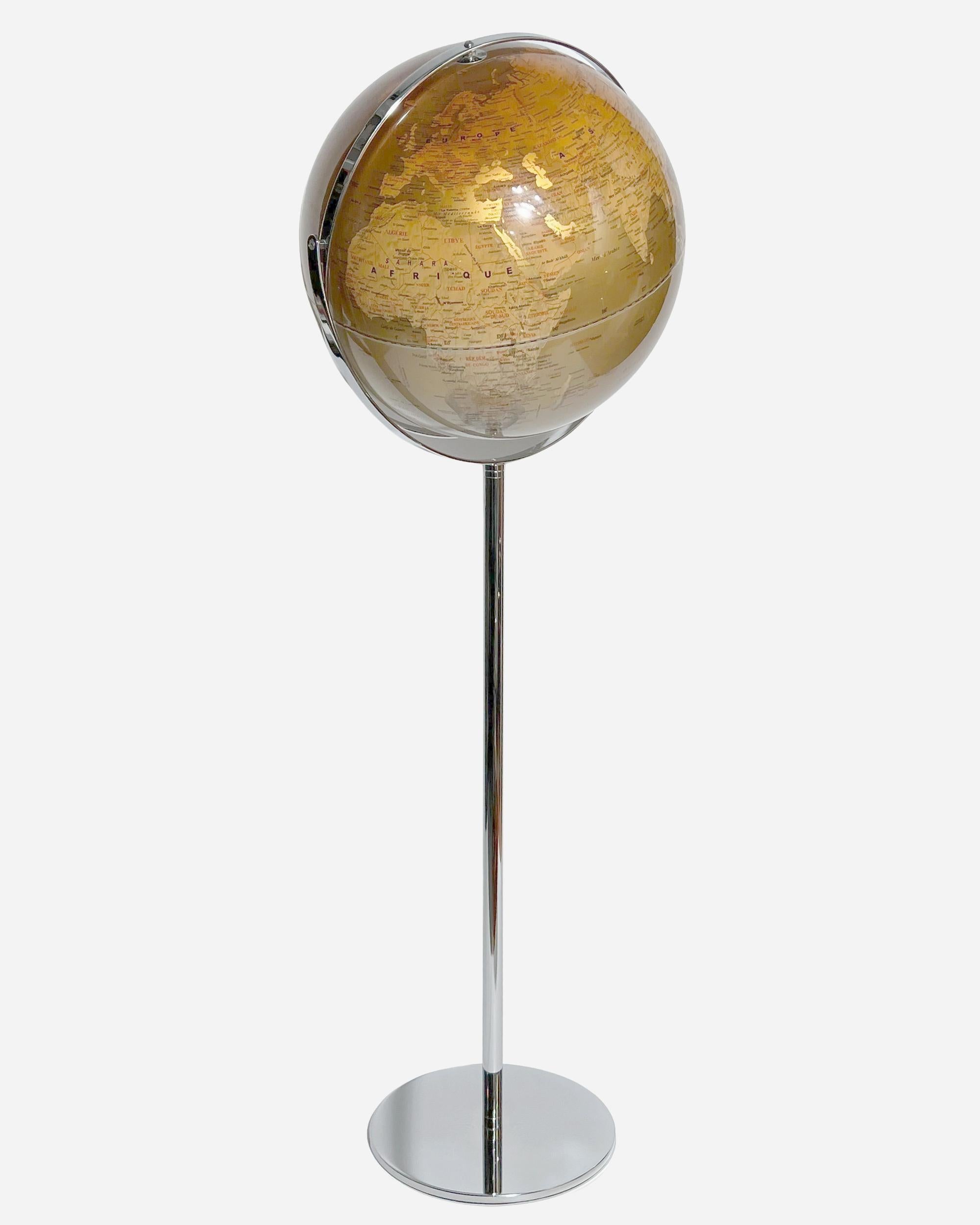 Large globe on a chrome metal stand.
The globe is made of gold-colored Plexiglas with variations of gold, and the mountain ranges are represented in slight relief.