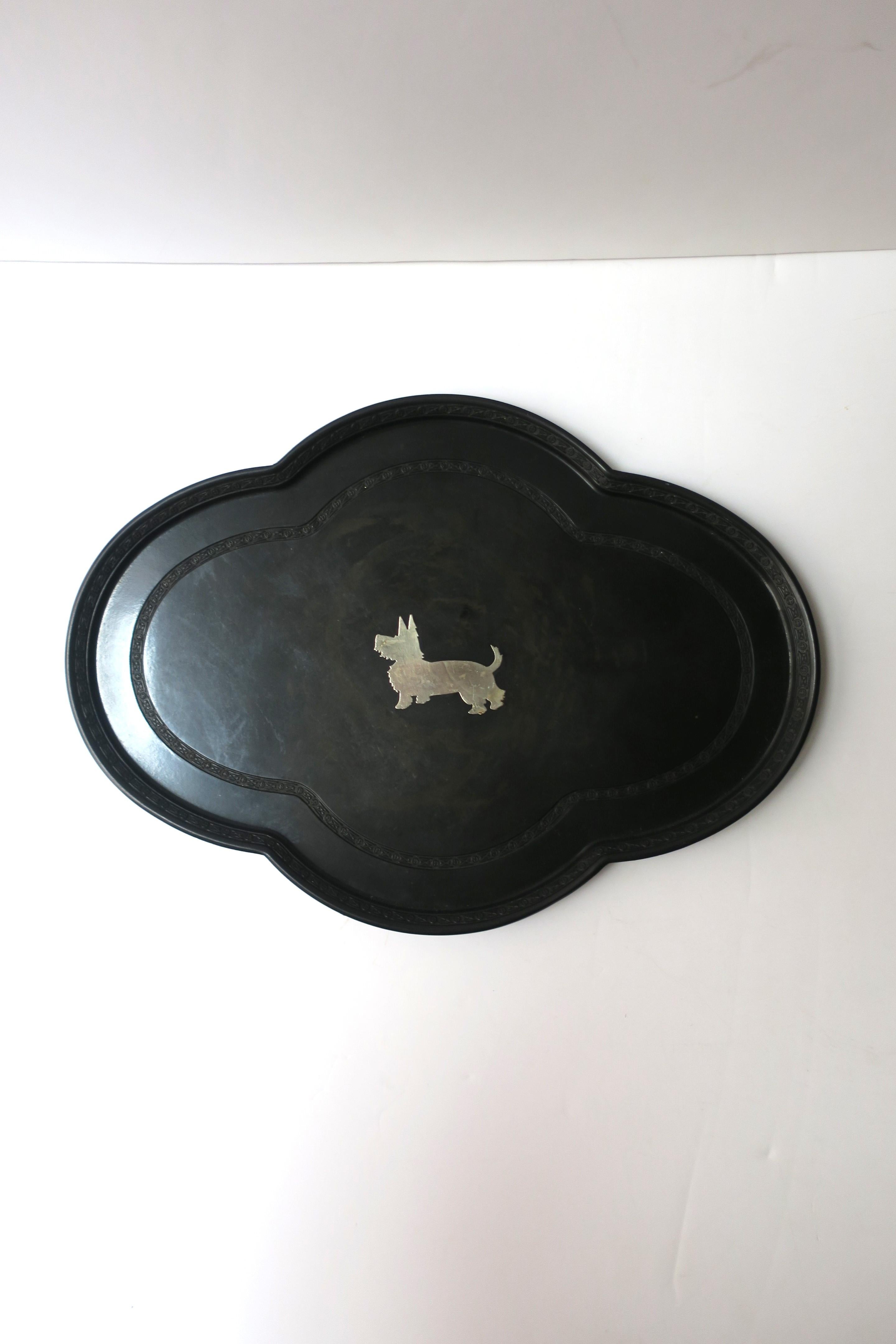 A black tray with inlayed terrier dog (possibly a Westie), quatrefoil shape, and detailed edge, circa mid-20th century. Use as a standalone piece (display), as a vanity tray (demonstrated), etc., many uses. Dimensions: 8.75