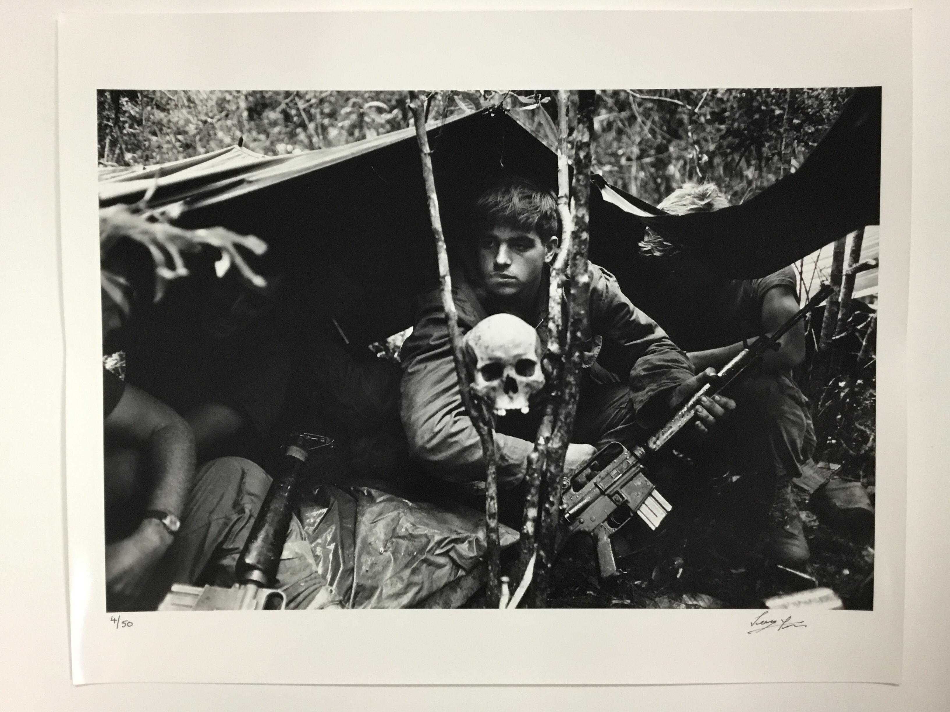 A human skull keeps watch over US soldiers encamped in the Vietnamese jungle during the Vietnam War. October 25, 1968 (Photo by Terry Fincher/Getty Images)

DETAILS
- Rare signed print, signature on front.
- Hand printed silver gelatin fibre