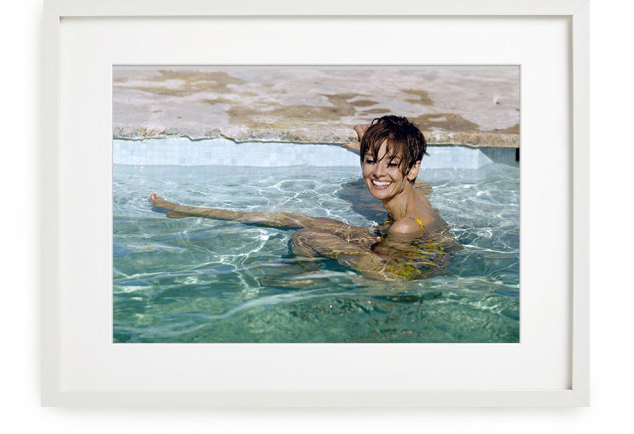 Terry O'Neill Portrait Photograph – Audrey Hepburn im Pool, 1966 - der Filmstar lächelt in einem gelben Schwimmanzug