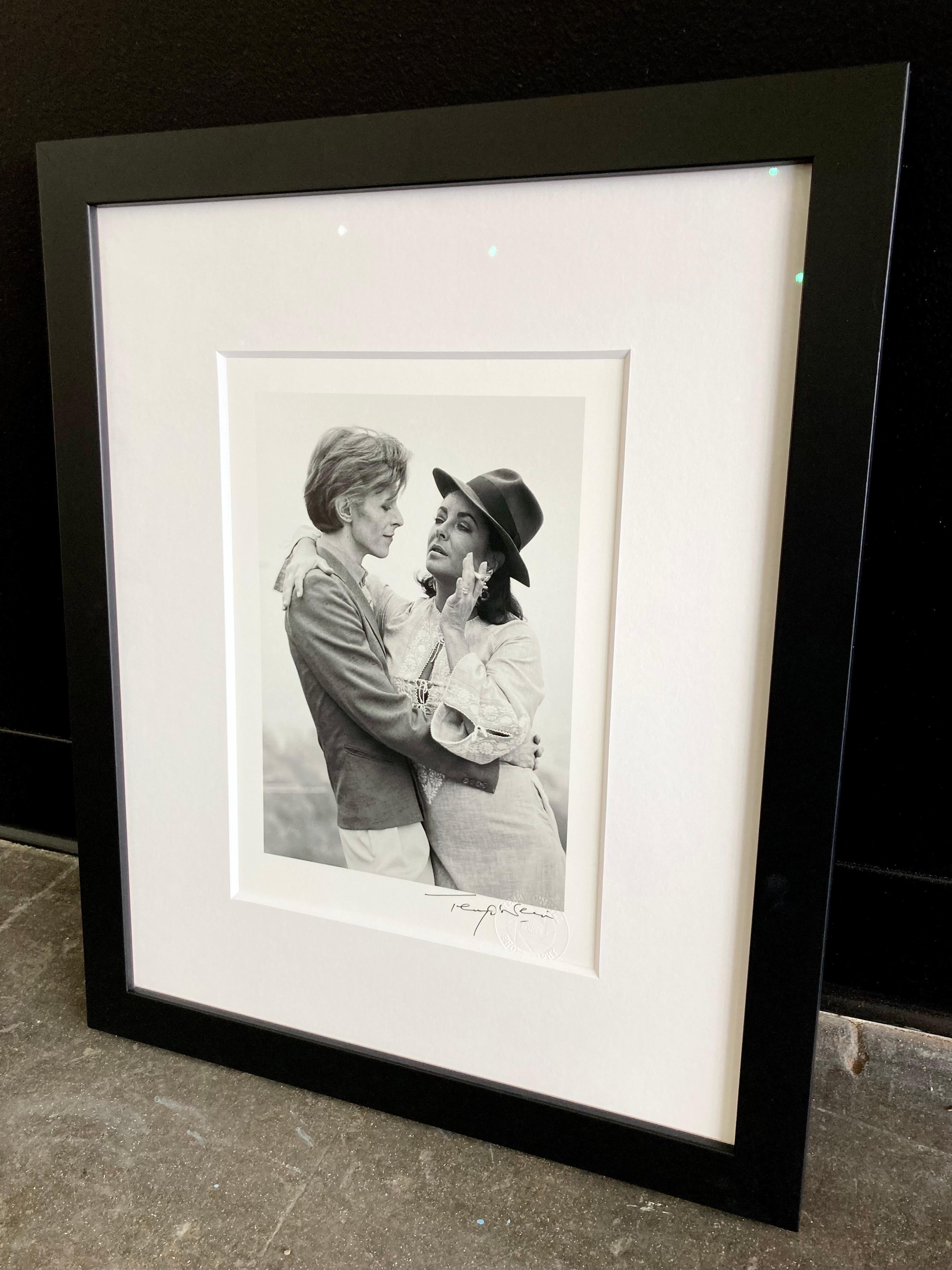 David Bowie and Elizabeth Taylor at director George Cukor’s home in Los Angeles, 1975, signed Terry O'Neill, 8x10" print, custom framed with non-glare museum glass, 8ply matting and a simple black frame.

This print was recently framed, so the frame
