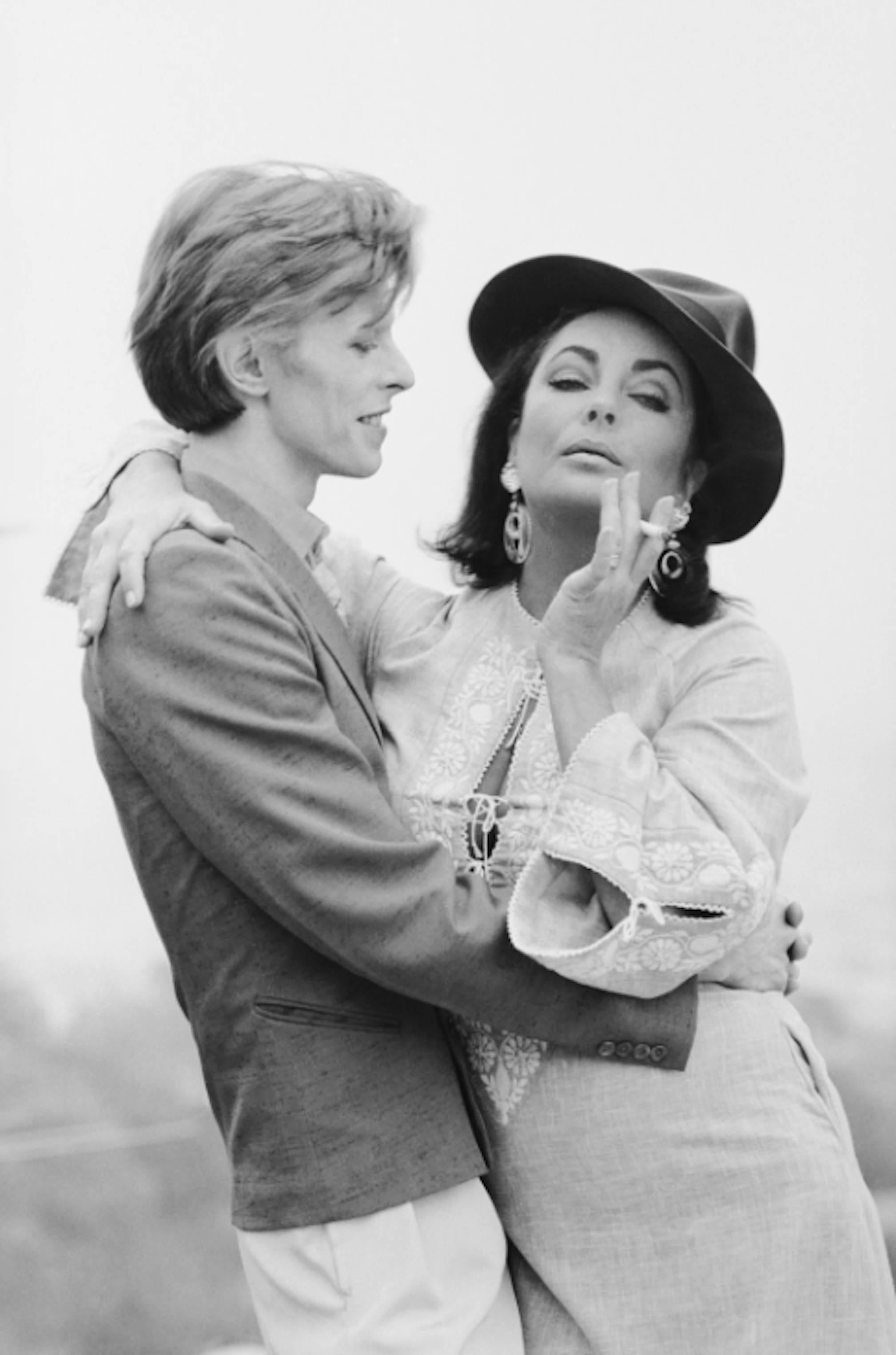 Terry O'Neill Black and White Photograph - David Bowie and Elizabeth Taylor, Beverly Hills, 1975
