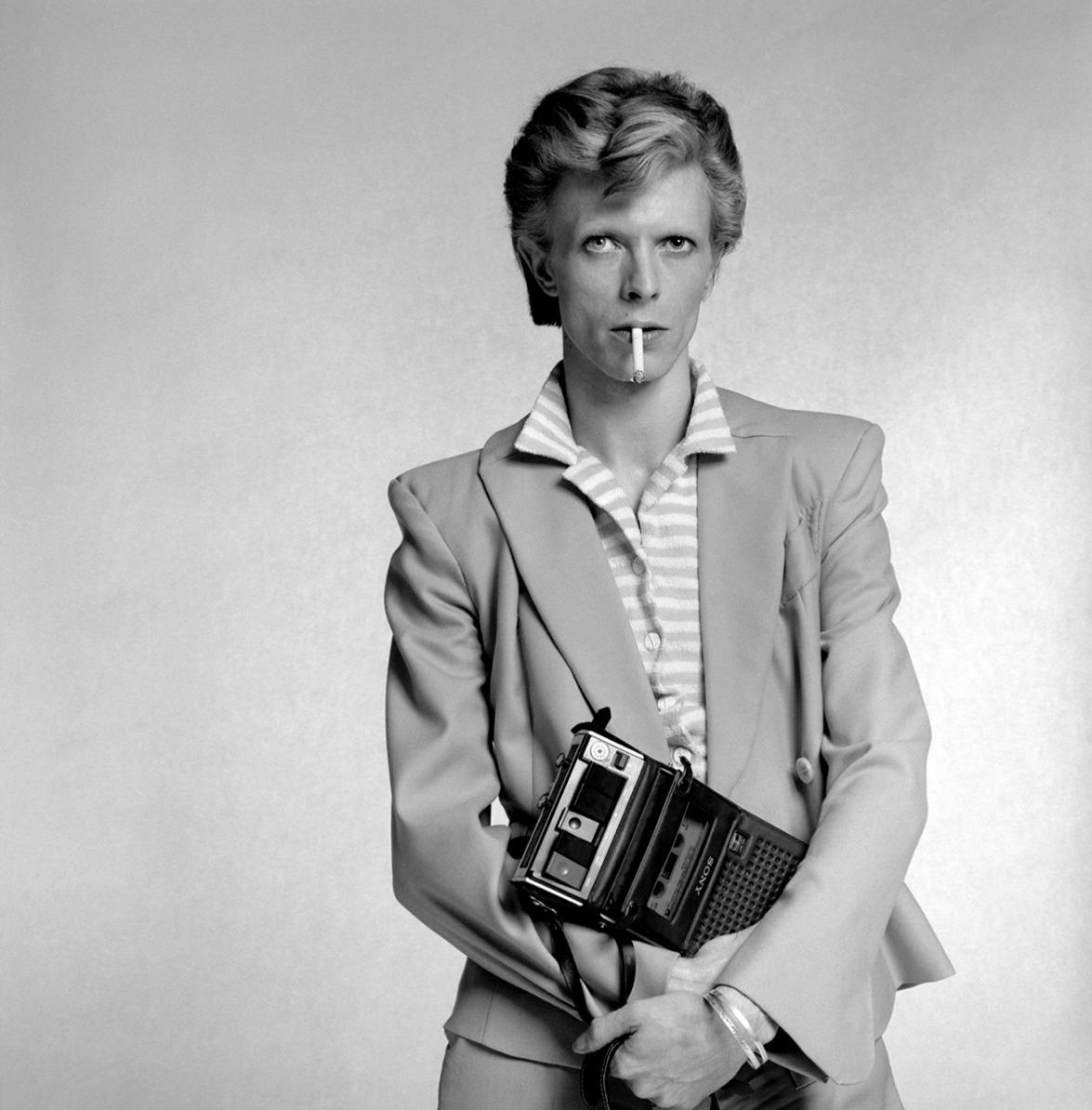 Terry O'Neill Portrait Photograph - David Bowie holds a cassette player, 1974 by Terry O’Neill