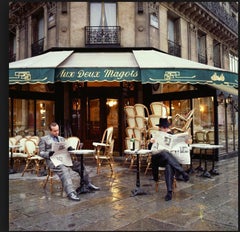 Die beiden Elton John und Bernie Taupin sitzen vor Aux Deux Magots