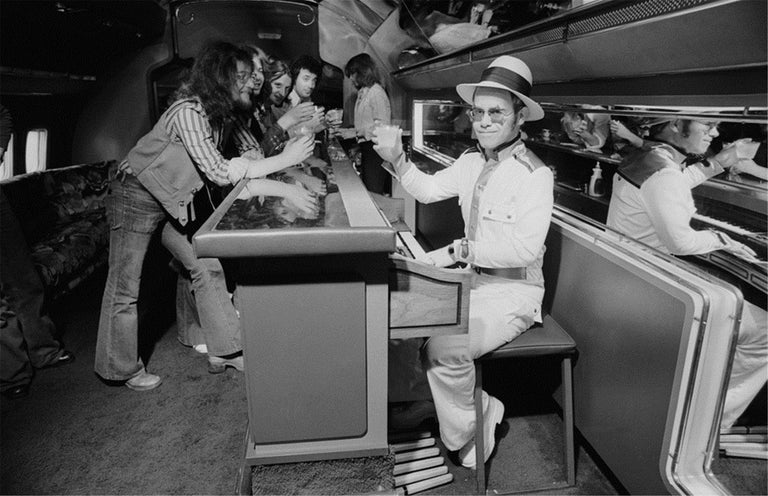 Terry O'Neill Black and White Photograph - Elton John on airplane