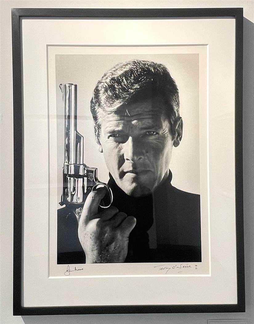 Roger Moore as James Bond (Co-signed) - Photograph by Terry O'Neill