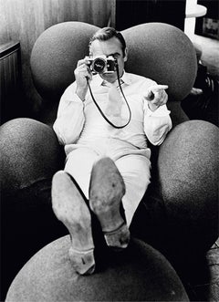 Sean Connery - the actor sitting on sofa with camera in is hand 