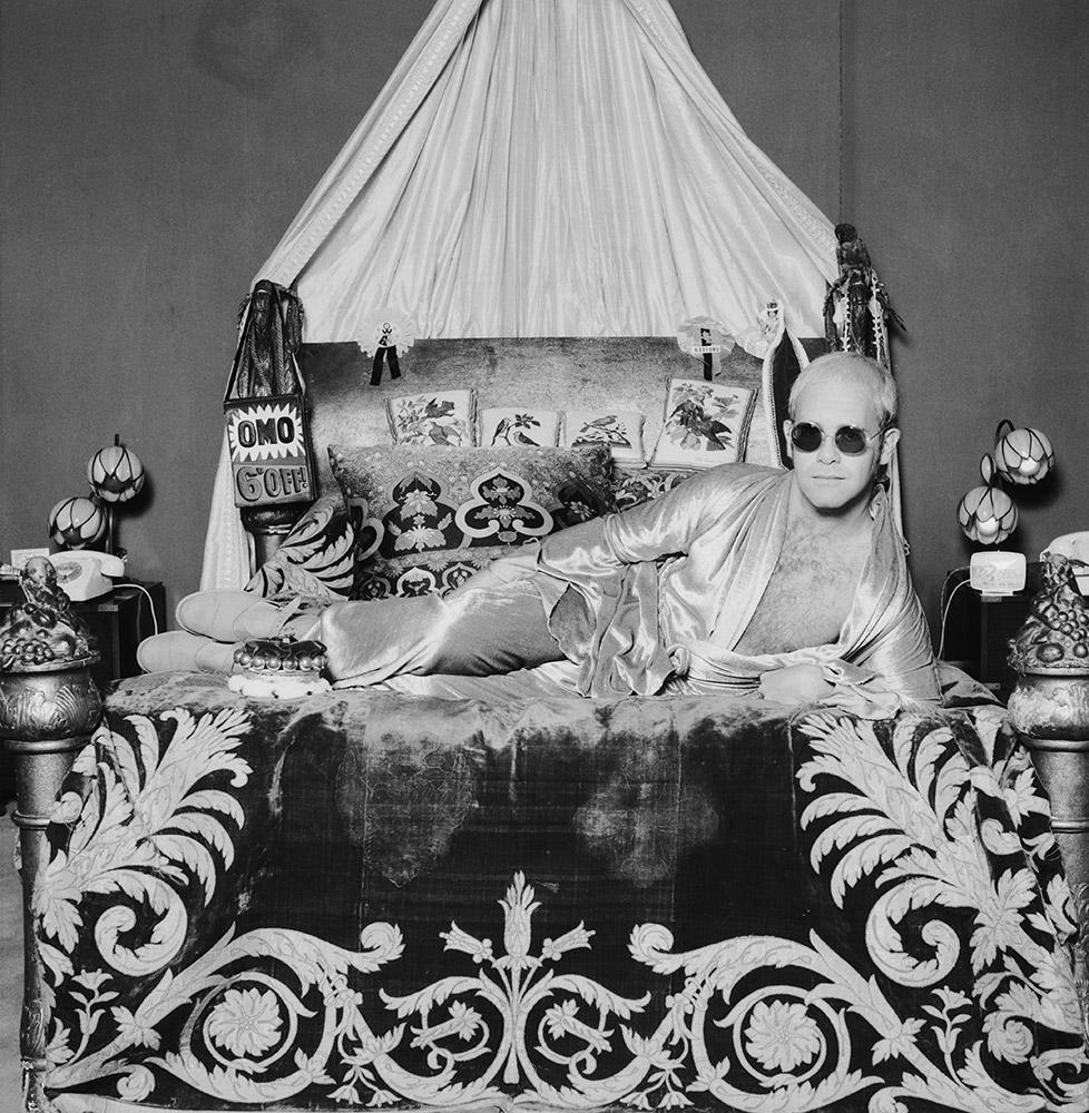 Elton John chez lui, 1972
Tirage à la gélatine argentique
20 x 20 pouces
Édition de 50 exemplaires numérotés et estampillés par la succession

La pop star et pianiste anglais Elton John est allongé sur un lit richement décoré, vers 1972.

Terry