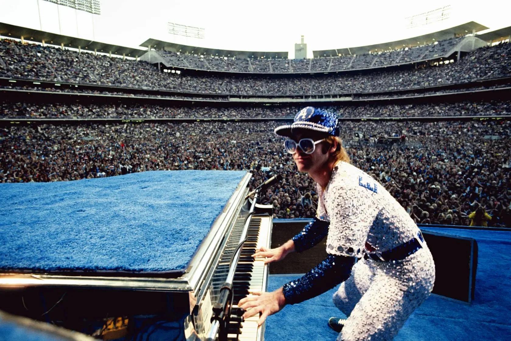 Elton John und sein Flugzeug, Los Angeles, CA
1975 (zuletzt gedruckt)
C-print
Posthume Nachlasssignatur gestempelte Auflage von 50 Stück mit Echtheitszertifikat 

In einer von Bob Mackie gestalteten, mit Pailletten besetzten Uniform der LA Dodgers