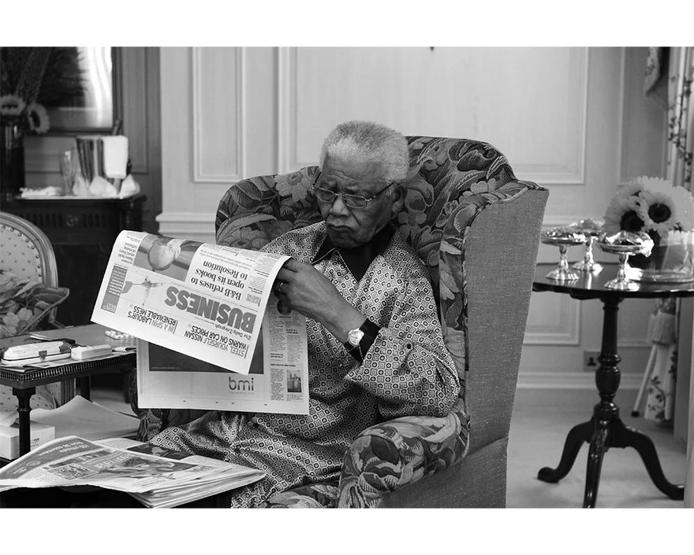 Nelson Mandela est photographié en train de lire le journal avant le concert d'hommage pour son 90e anniversaire qui s'est tenu à Hyde Park, à Londres, le 27 juin 2008. Cet événement s'inscrit dans le cadre de la série de concerts 46664 visant à