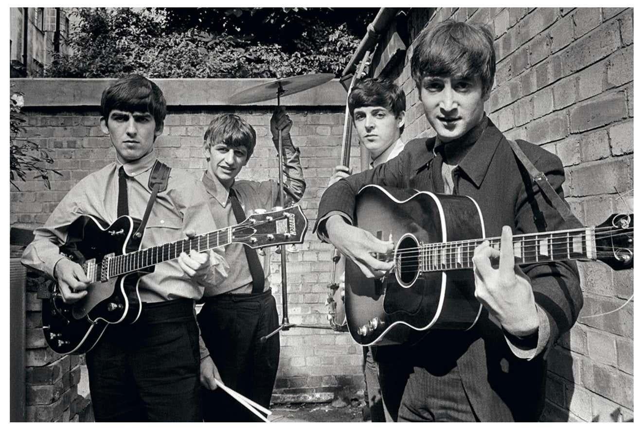 Terry O'Neill Portrait Photograph - The Beatles Backyard - the young superstars playing their instruments