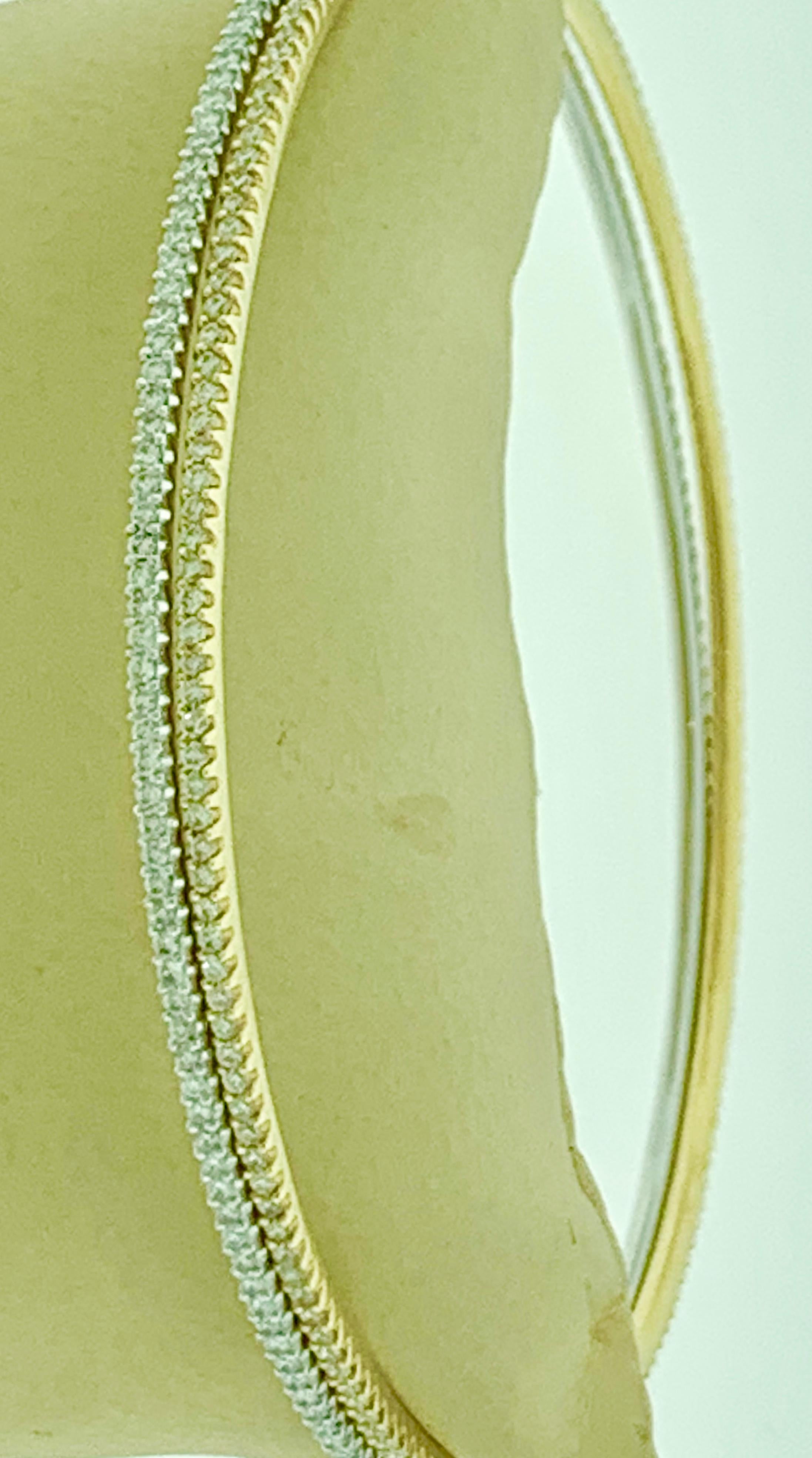 The Tesora Contemporary Yellow & White 18 Karat Gold & Diamond Bangle Bracelet is a beautiful piece of jewelry that is sure to turn heads. It features two bangles that are crafted from 18K Yellow gold and 18K white gold, with approximately 2 Carats