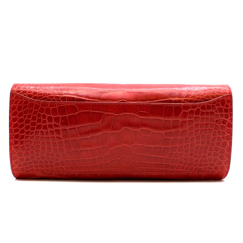 Tess Van Ghert - Red American Alligator Clutch

- magnetic flap closure
- pearlescent finish
- red suede lining 
- 3 interior compartments, 1 with flap snap button closure 
- exterior slip pocket on the back
- chain not included

- American