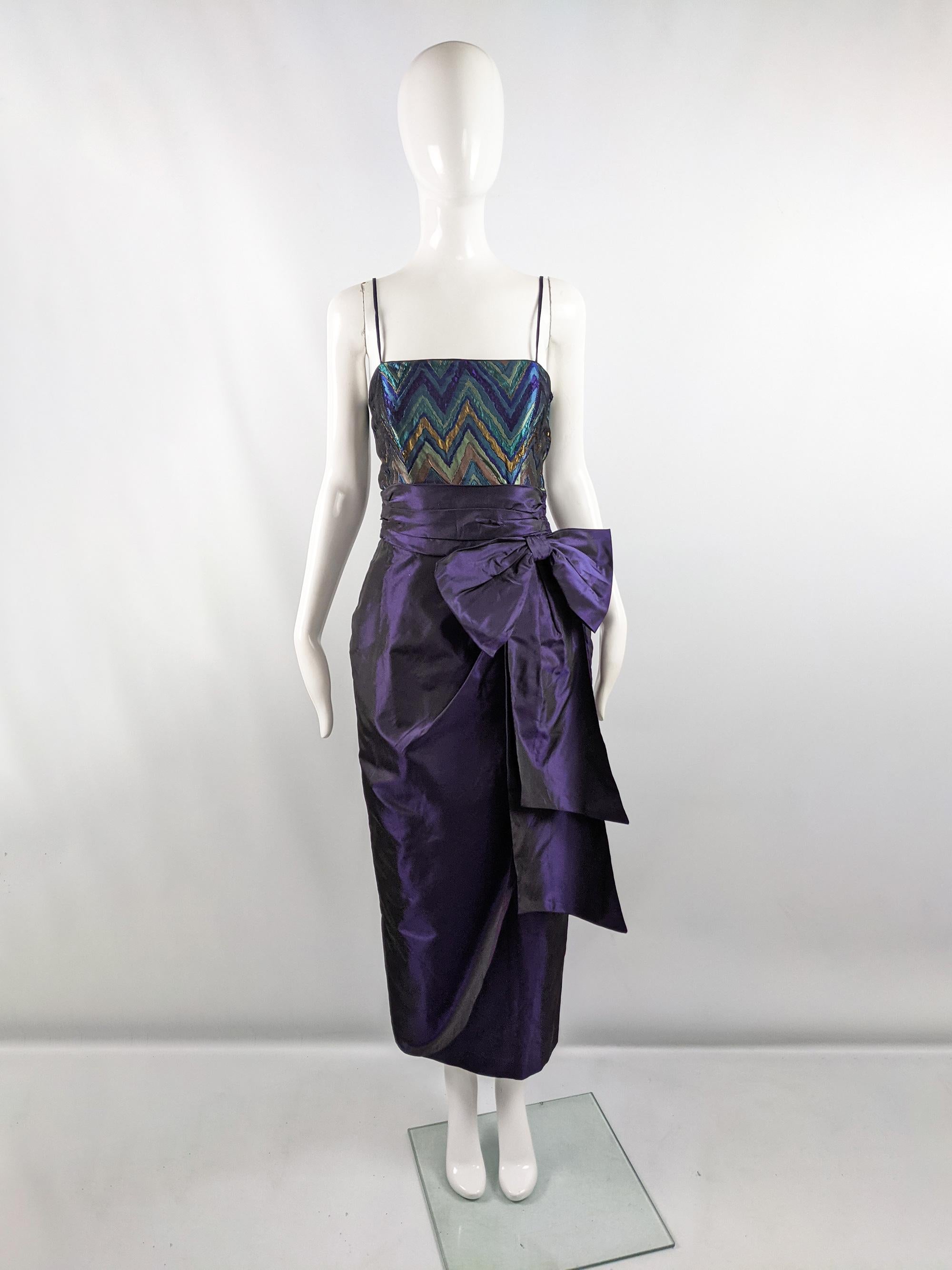 A fabulous vintage womens sleeveless maxi evening dress from the 80s by quality British fashion designer, Tessara. In a purple taffeta with a dark iridescent hue and a teal brocade fabric on top. It has a flattering ruched waist with a dramatic,