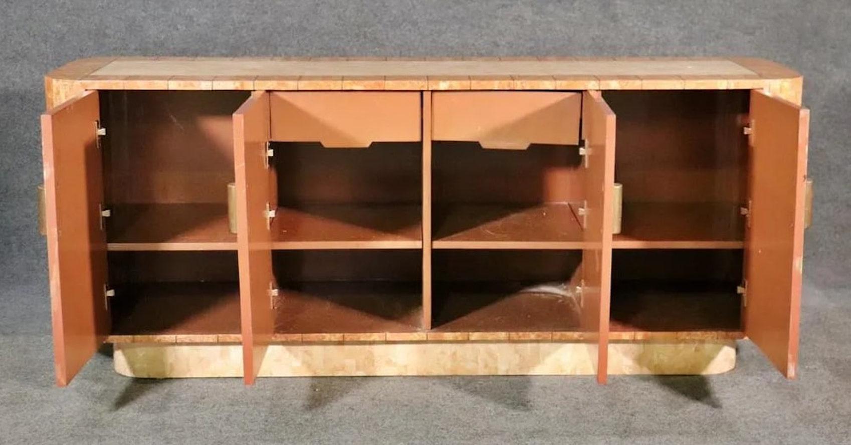 Vintage cabinet made with tessellated stone with inlaid brass trimming. Made in an art deco fashion with ample storage for home or office.
Please confirm location NY or NJ