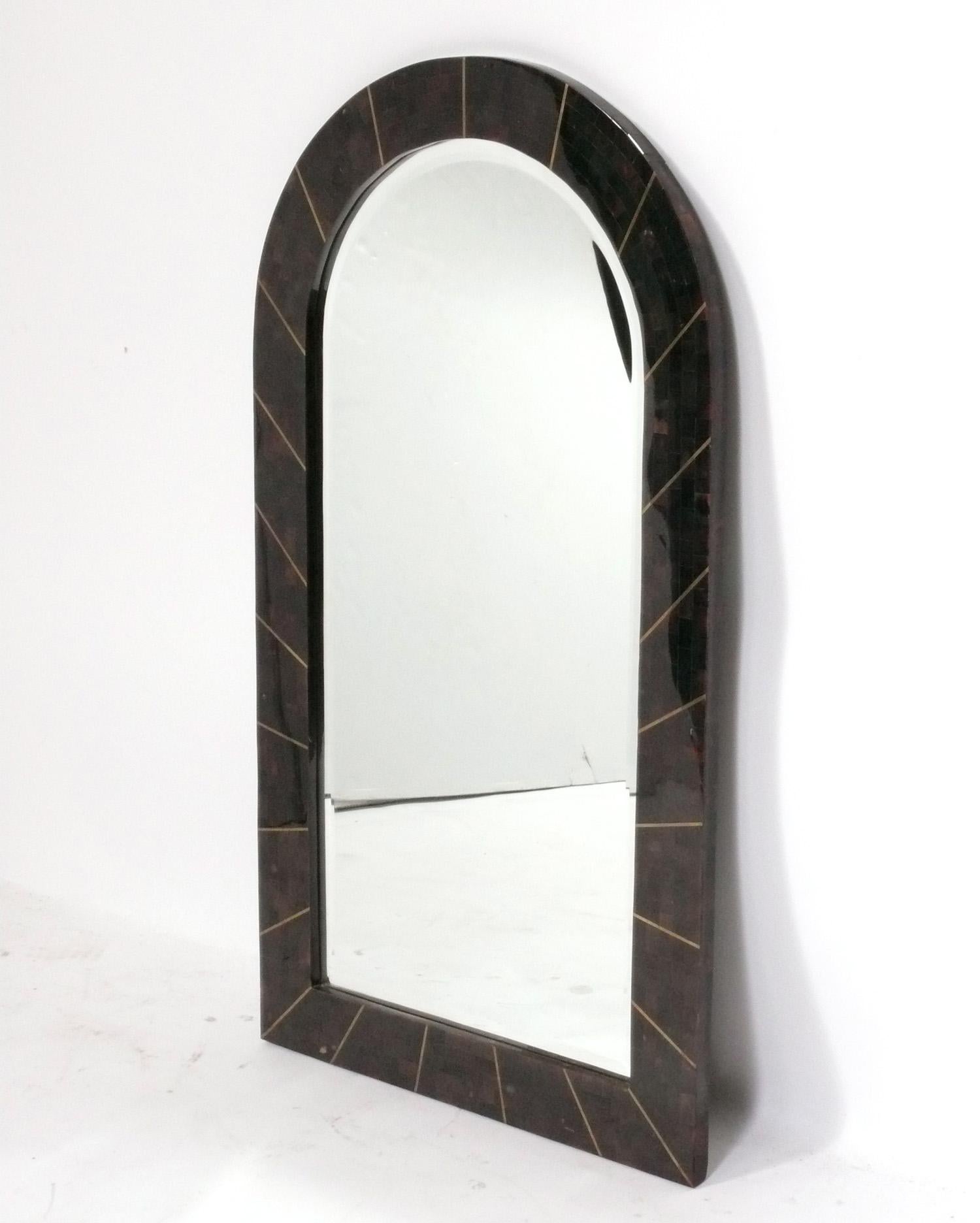 Tessellated arched mirror with brass inlay in the style of Karl Springer, American, circa 1980s. It measures an impressive 43.25