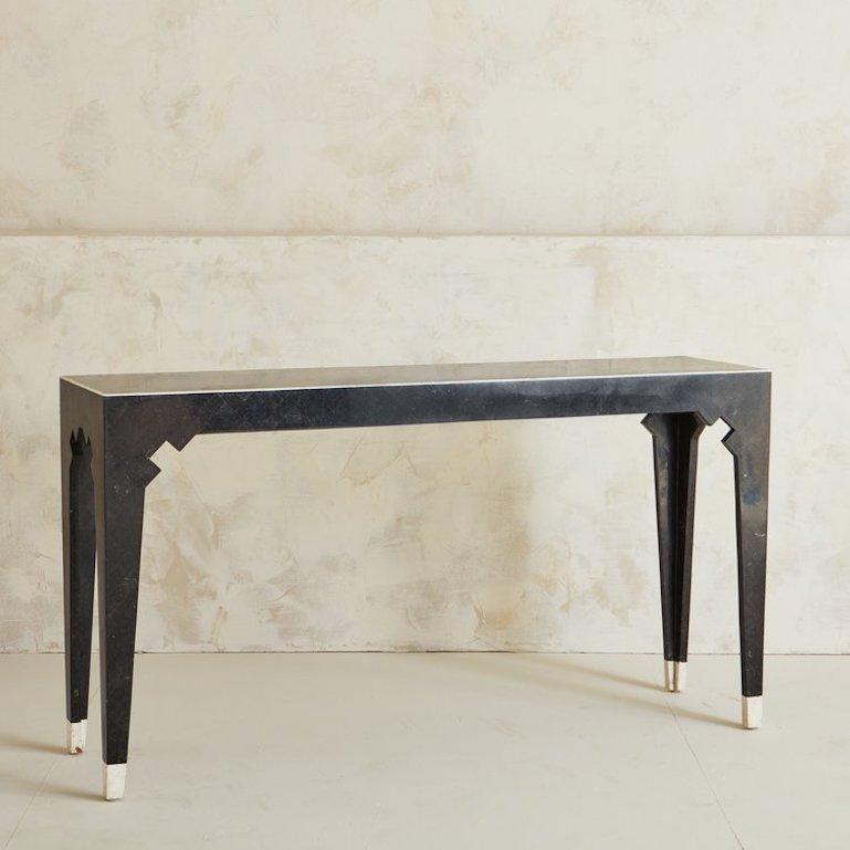 A handsome 1980s tessellated black marble console table designed by Maitland Smith. This table was handmade in the Philippines using black marble tiles and features an off-white marble tile trim and feet. Retains original ‘Hand Made in the