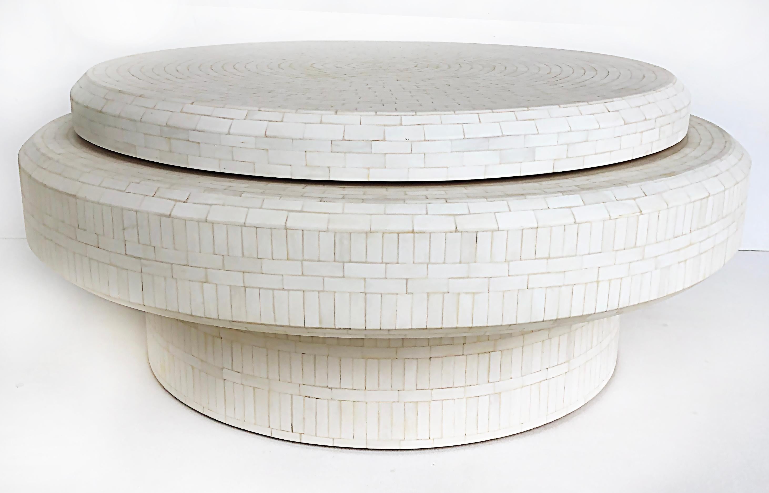Tessellated bone 2-tiered rotating coffee table in the Manner of Karl Springer 

Offered for sale is a tessellated bone, two-tiered coffee table with a rotating upper level that extends outwards expanding the size of the table. This table was just