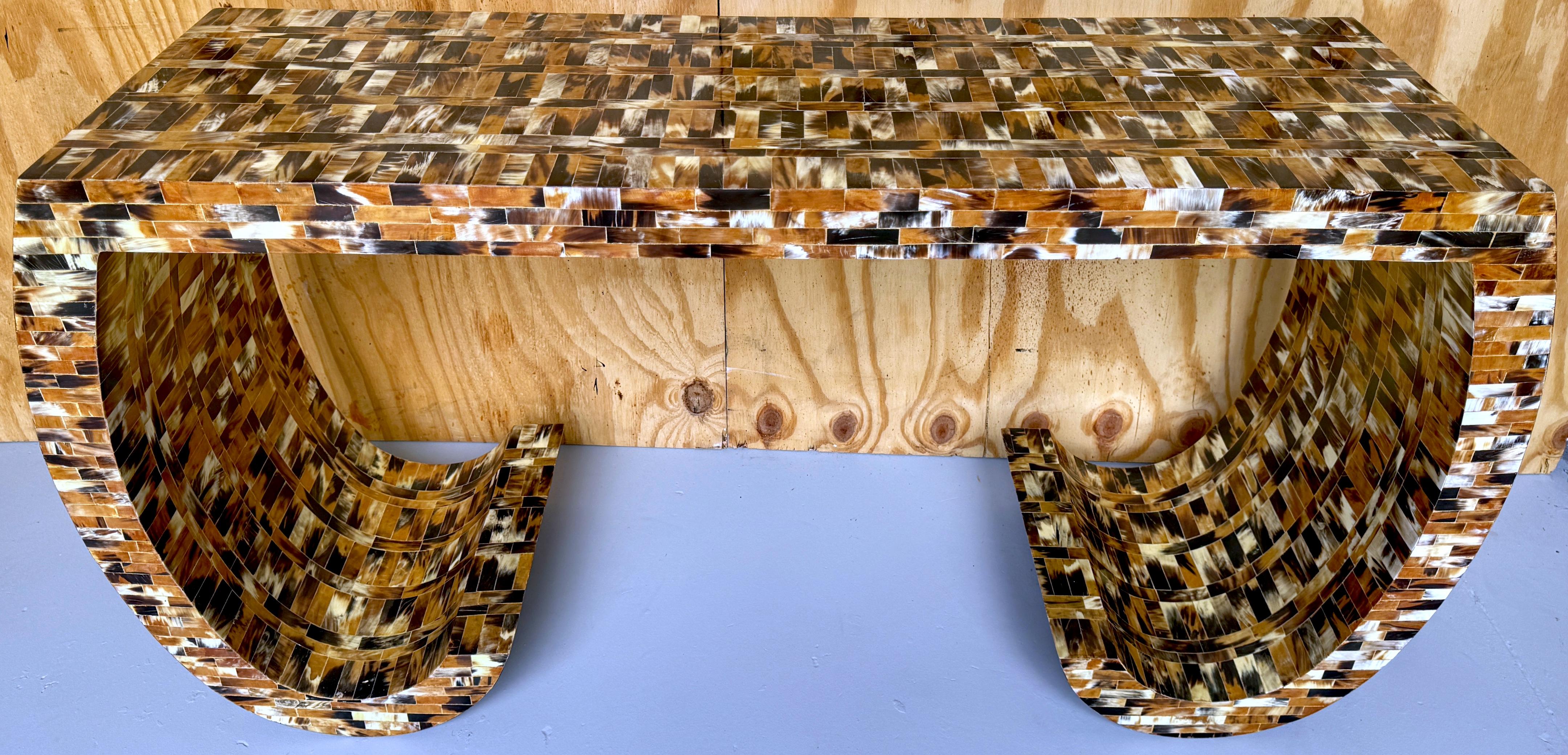 Tessellated Cow Horn Scroll Leg Console Table by Enrique Garcel, circa 1980s
Colombia, circa 1980s

Elevate your living space with the exquisite Tessellated Cow Horn Scroll Leg Console Table by renowned Colombian designer Enrique Garcel, circa 1980s