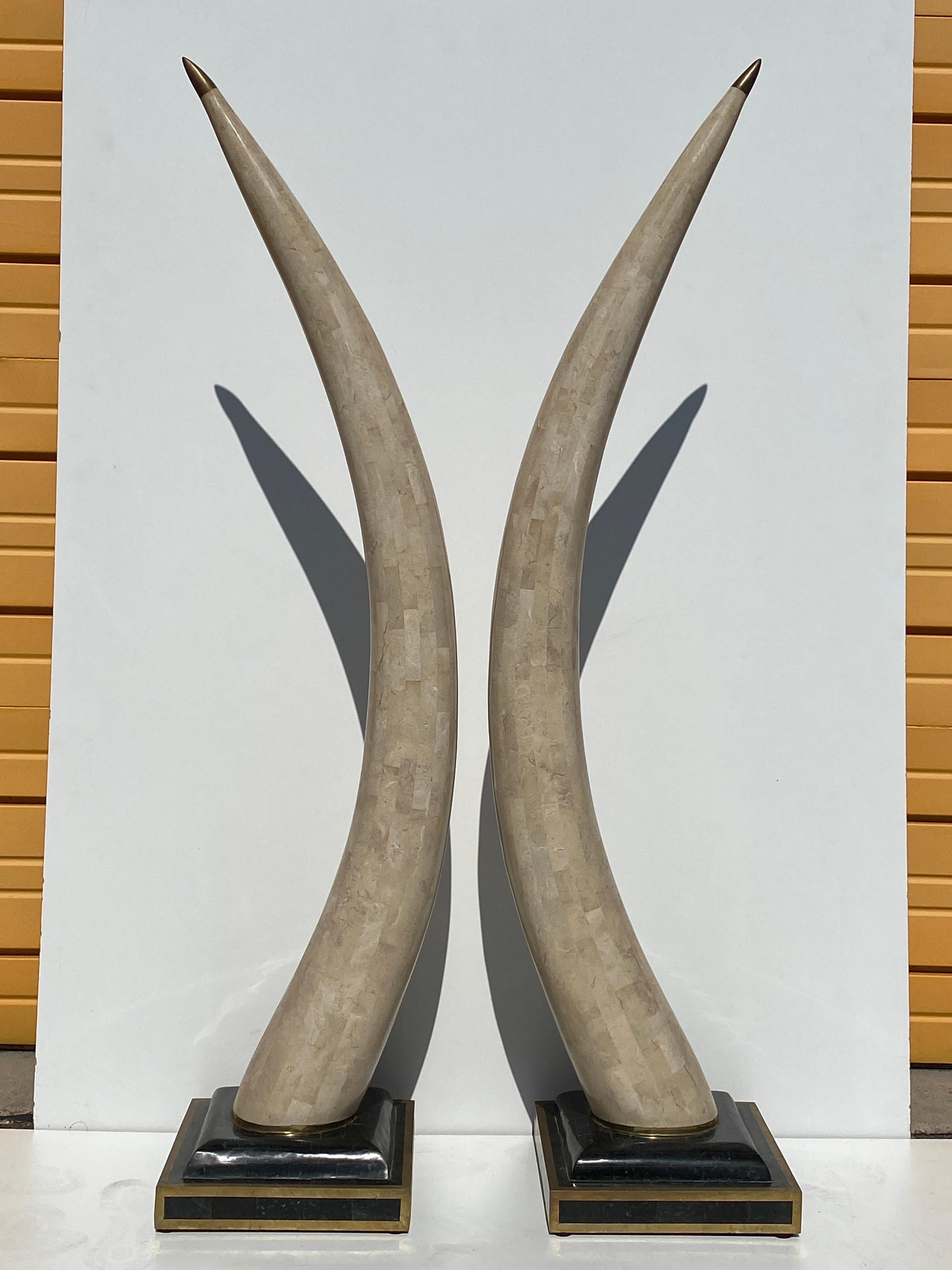 Pair of Maitland Smith faux elephant tusks made of tessellated fossil coral and horn with brass details. Each tusk is 58