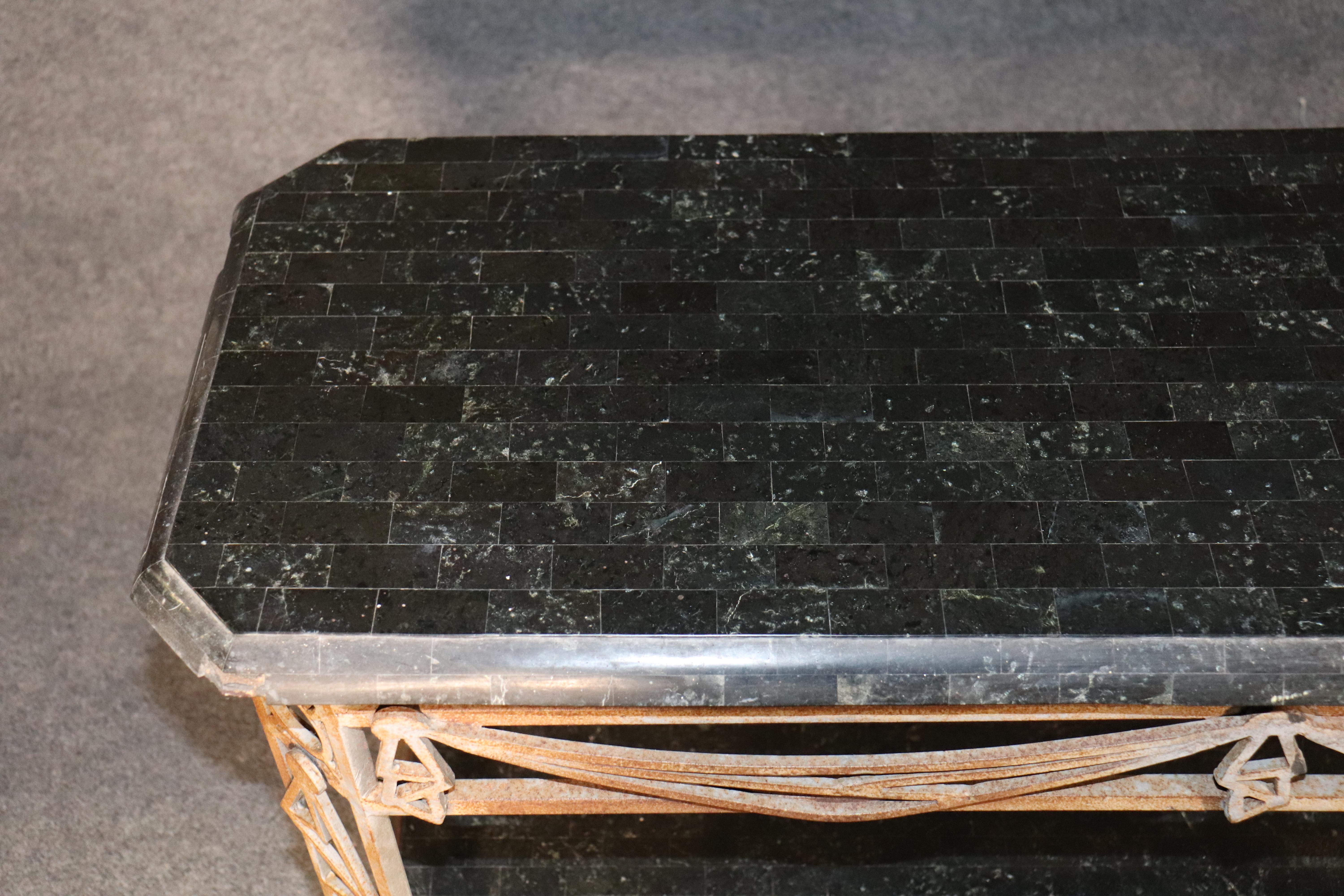 Long stone top console table with heavy iron base. Tessellated marble top with striking color set atop a well worn and patina iron base with scrolling decoration.
Please confirm location.
