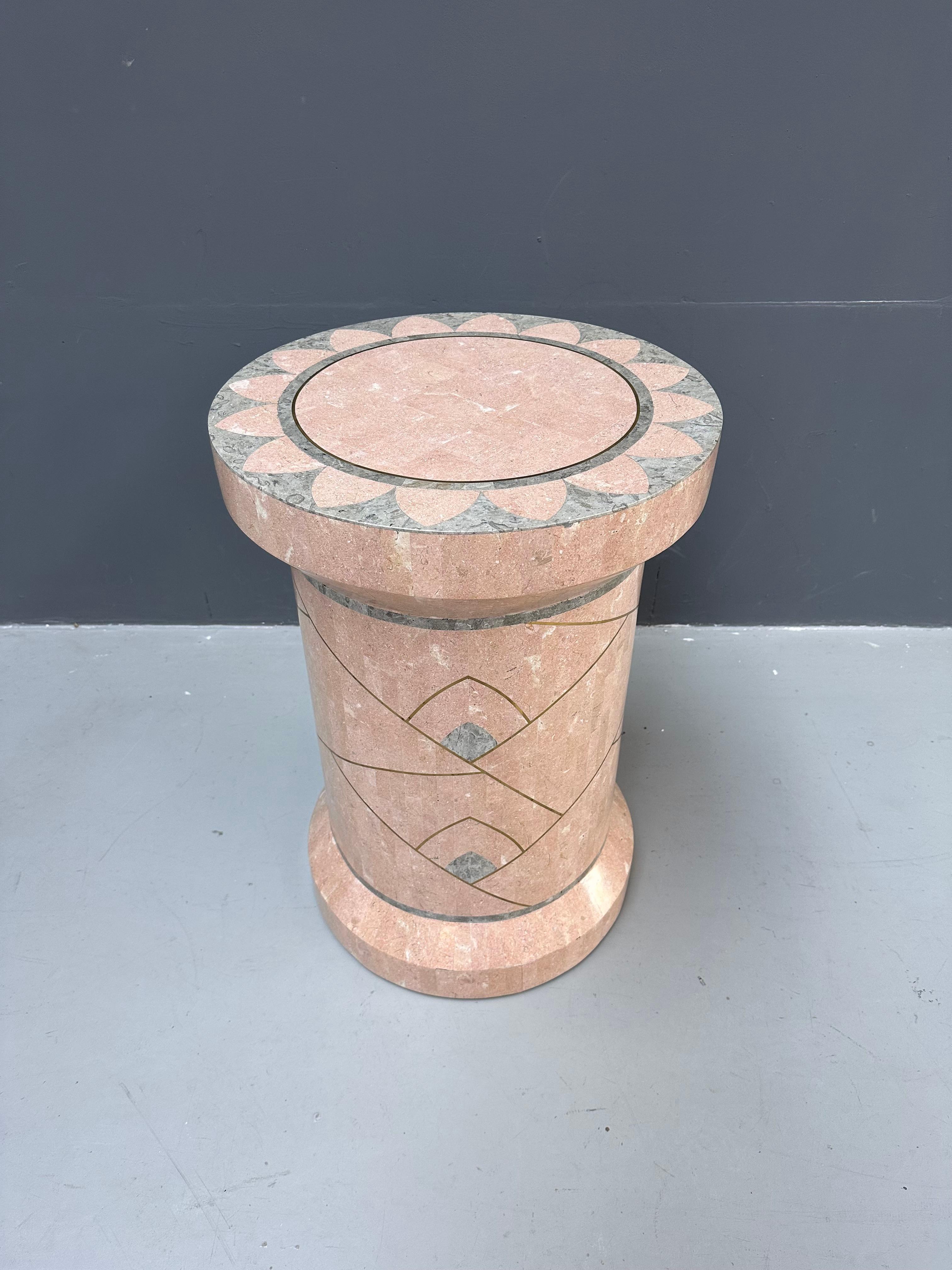 A true vintage large pedestal made of a tessellated structure of stone and marble pieces. It has a smooth surface with pink and salmon colored little tiles and brass inlay. Designed by Robert Marcius and Handmade in the seventies by Casa Bique in