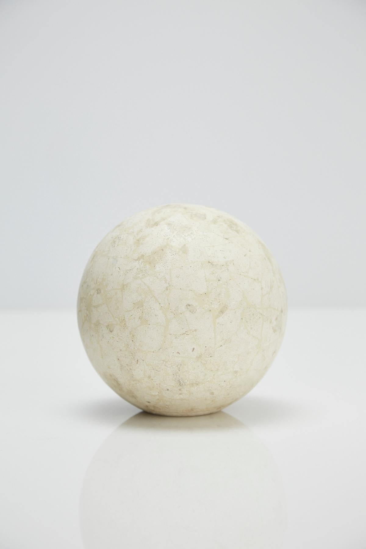 Postmodern tessellated stone sphere executed in matte Mactan stone over a fiberglass body.

Pair available. Measures: 5.5 inches diameter.

All furnishings are made from 100% natural Fossil Stone or Seashell inlay, carefully hand cut and crafted