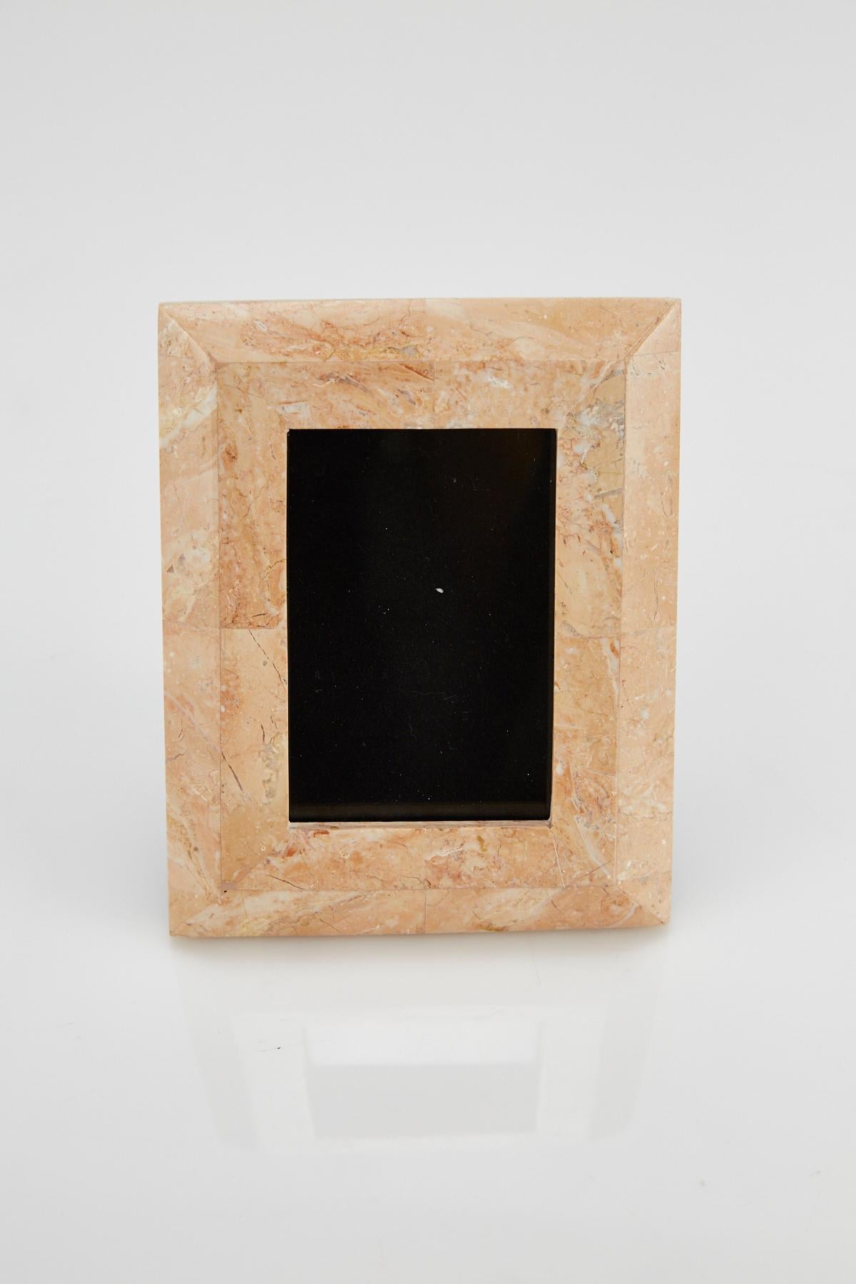 Rectangular picture frame in tessellated peach stone with black felt back. Opening for picture measures 4 1/4 x 2 3/4 in., frame overall measures 7 x 5 1/2 in.

All furnishings are made from 100% natural Fossil Stone or Seashell inlay, carefully