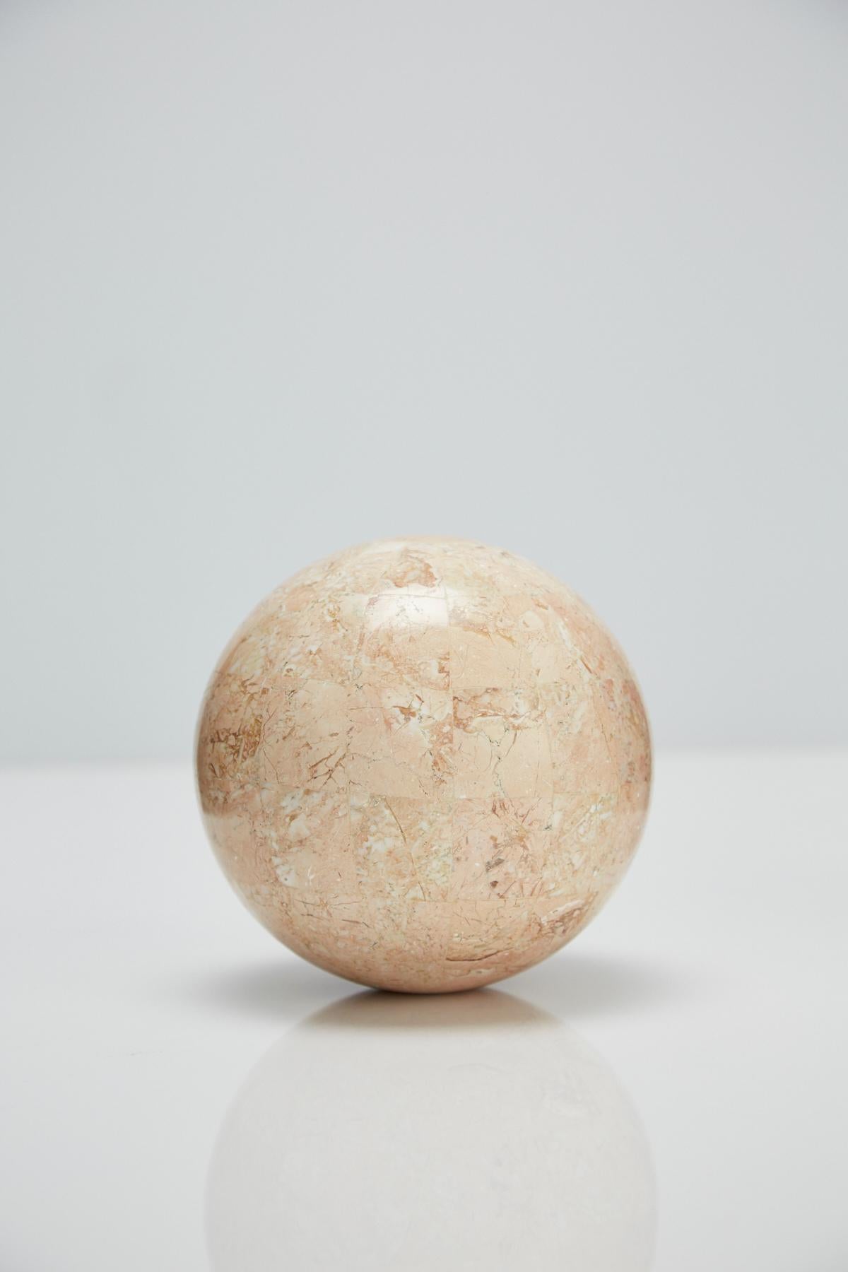 Postmodern tessellated stone sphere executed in peach stone over a fiberglass body. Measures: 5.5 in. diameter

Pair available.

All furnishings are made from 100% natural Fossil Stone or Seashell inlay, carefully hand cut and crafted piece-by-piece