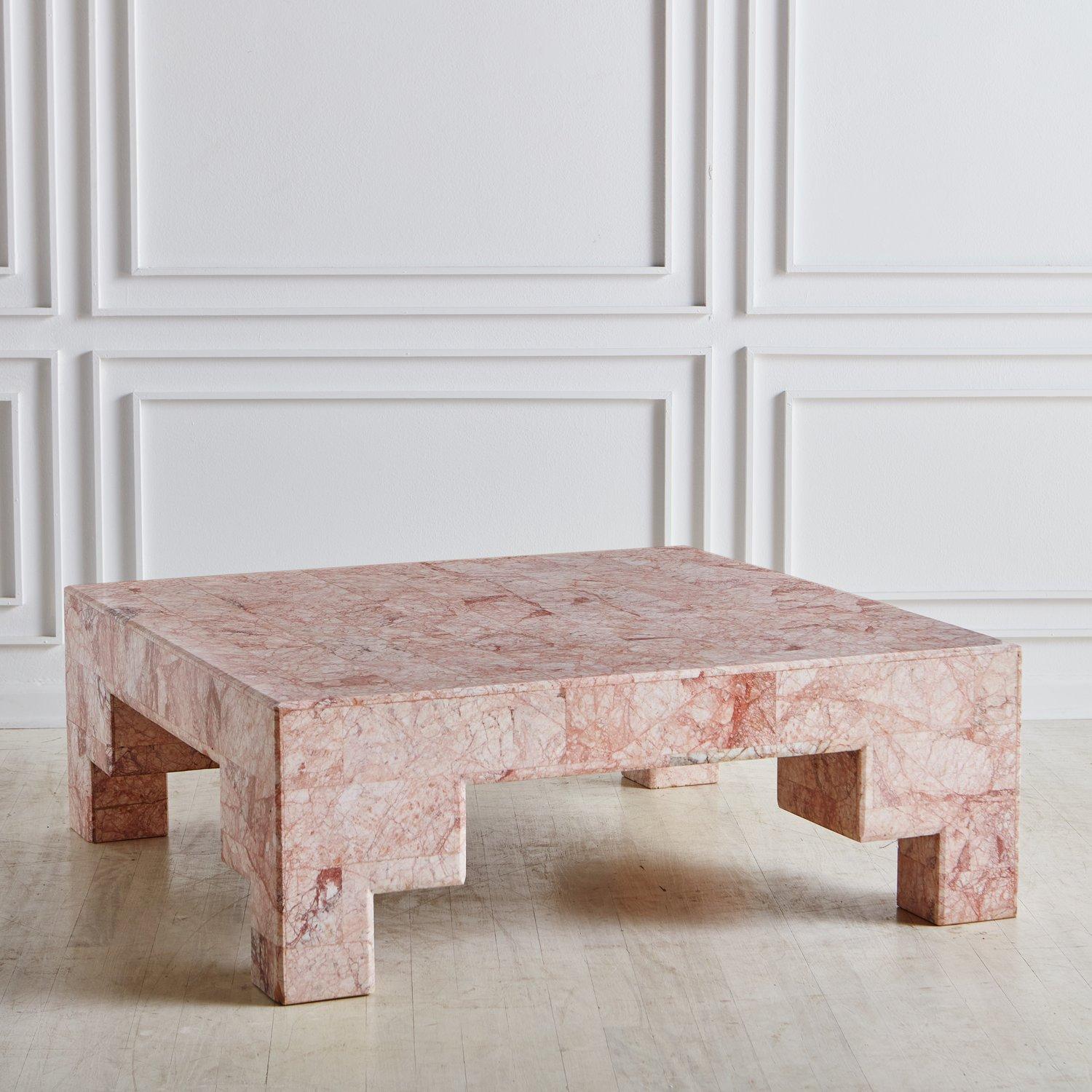 A monumental square coffee table constructed with wood clad in a tessellated pink spider marble with gorgeous pink, coral and white veining. This table has four sculptural block legs with geometric cutout details. USA, 20th Century.

