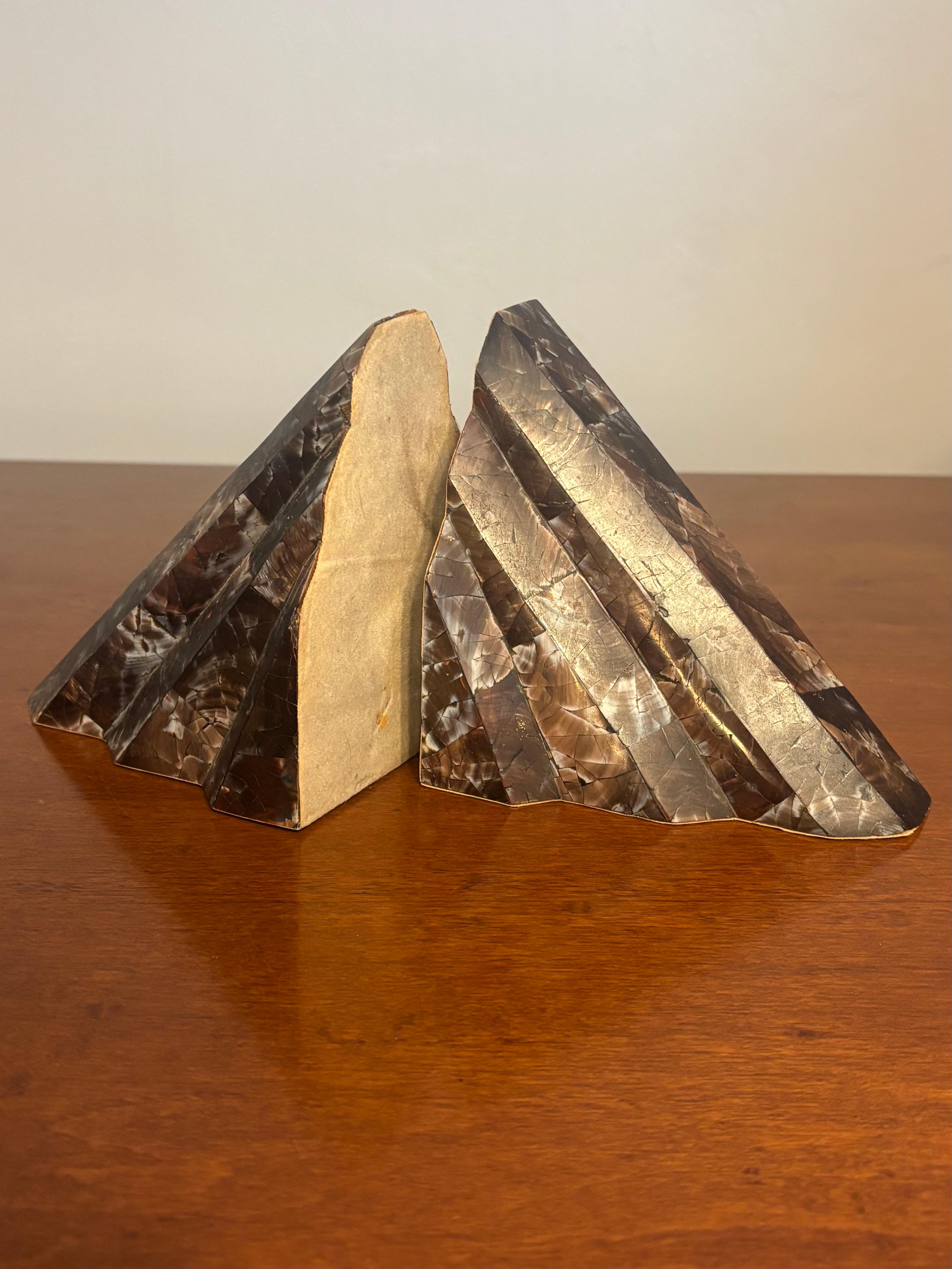 Une paire raffinée de serre-livres en coquillages tessellés dans le style de Lumin, conçus avec une géométrie architecturale et un matériau naturel lumineux. Chaque forme triangulaire s'élève comme une montagne stylisée - une rencontre entre le