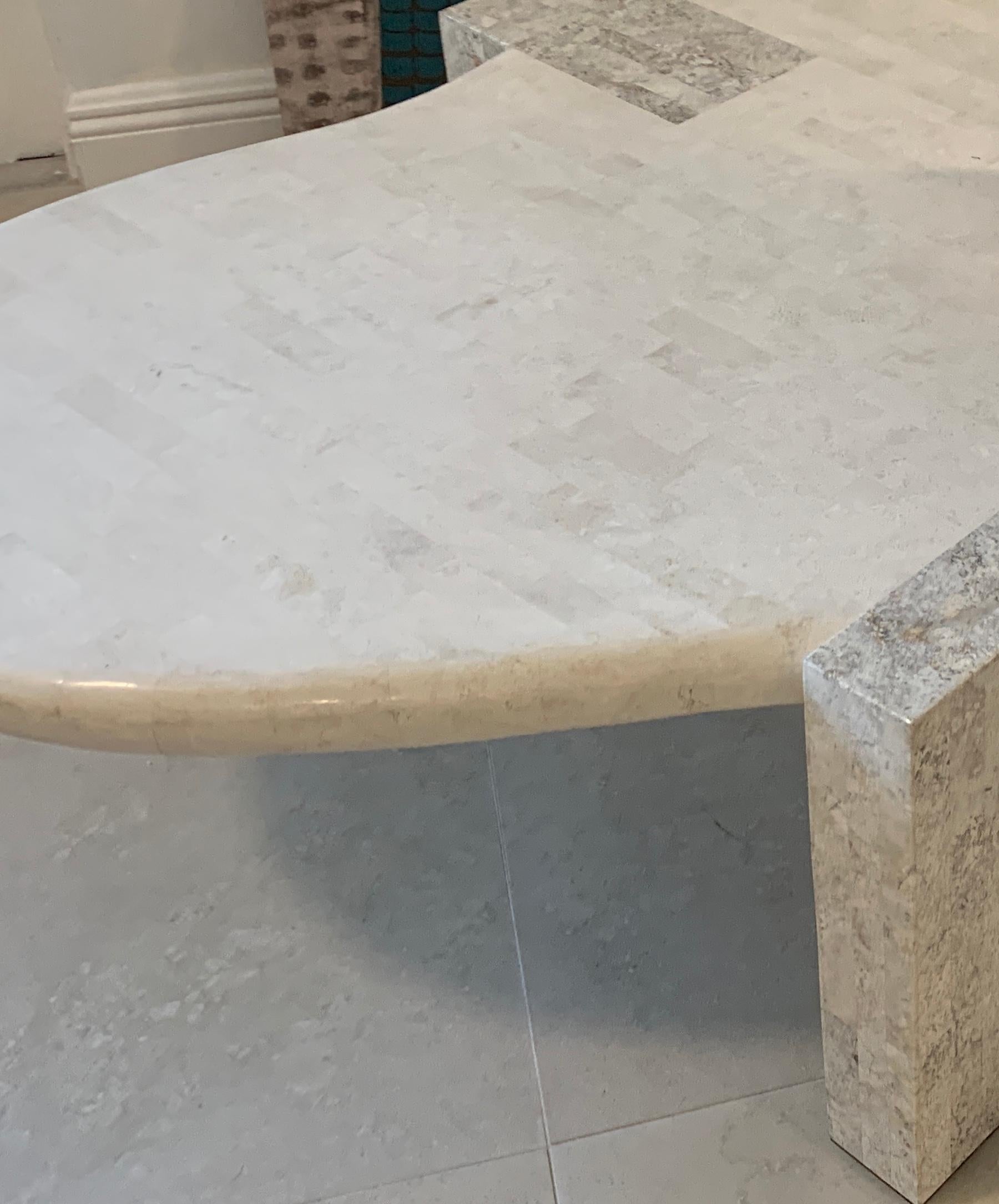 Tessellated stone biomorphic coffee table, by Maitland Smith
A substantial table beautifully and seamlessly crafted in two color neutral stone, raised on three dovetailed rectangular block legs.
 