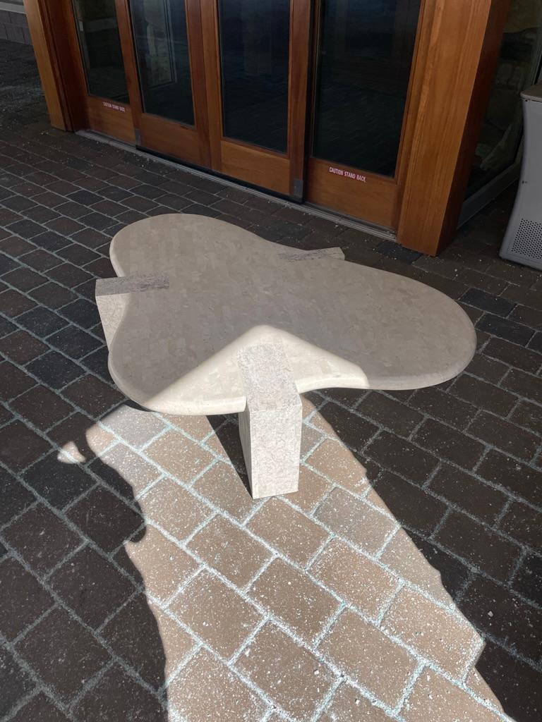 Tessellated stone biomorphic coffee table by Maitland Smith.
A substantial table, beautifully and seamlessly crafted in two color neutral stone, raised on three dovetailed rectangular block legs. In incredible condition with minor wear.