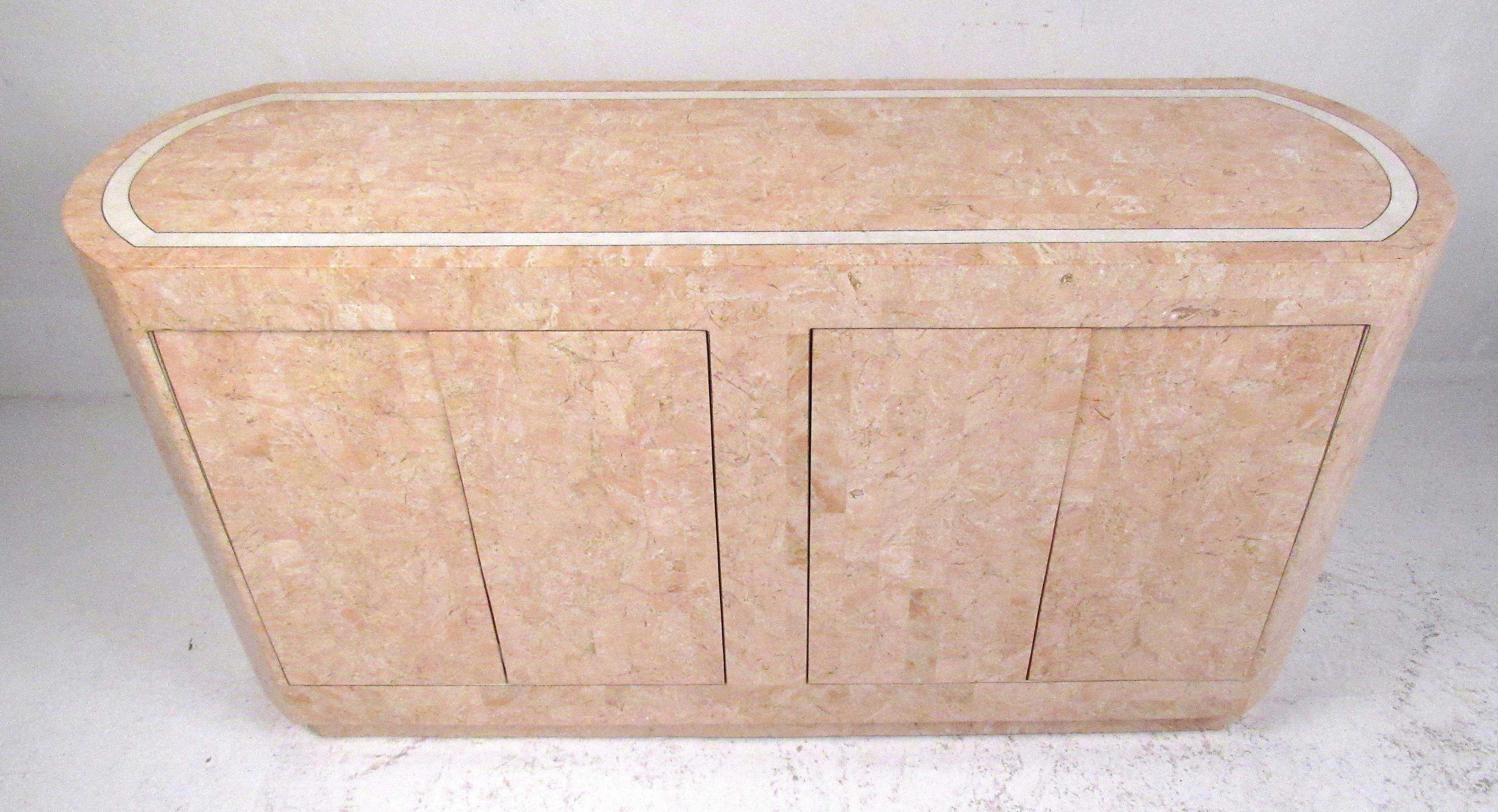 Salmon colored four-door tessellated stone buffet with two storage drawers and two adjustable shelves. 
A smaller-scale cabinet that can be used as a buffet, a console cabinet behind a sofa, or as a freestanding dry bar. Please confirm item