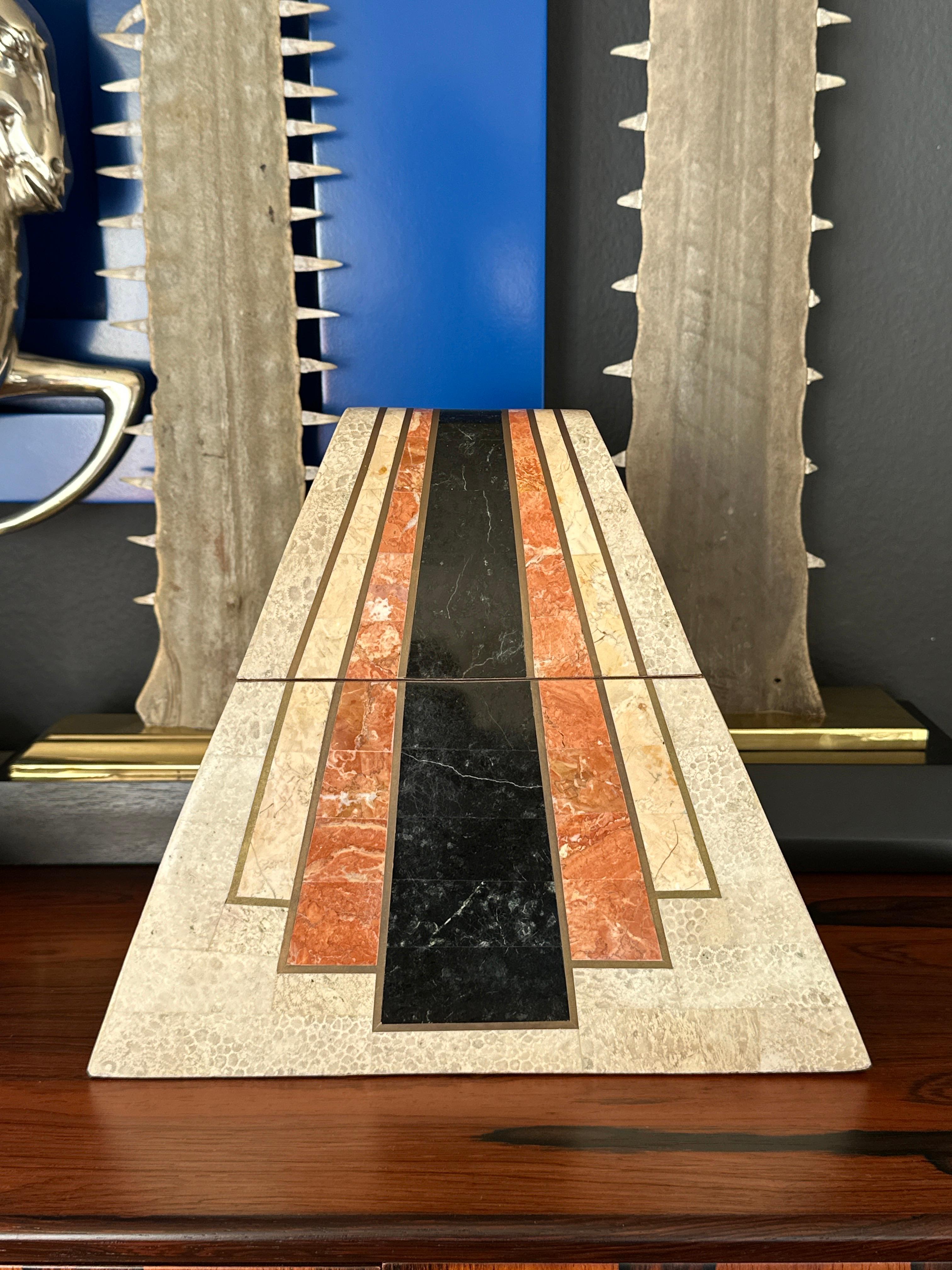 Joyero decorativo de piedra exótica teselada con incrustaciones de latón e interior de terciopelo atribuido a Maitland Smith 
El interior de la caja mide 15 cm x 15 cm x 15 cm de profundidad.