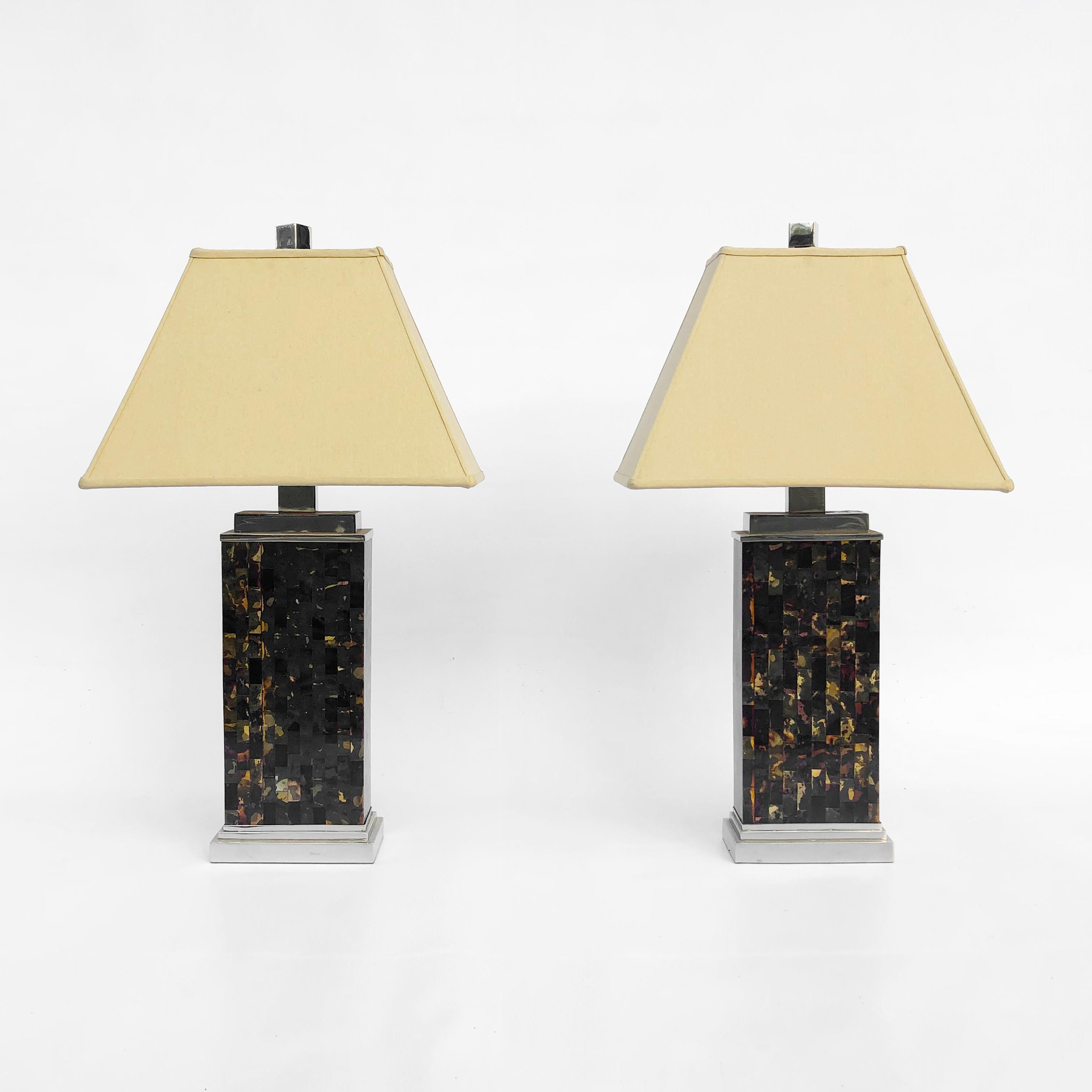 Elegant pair of 1970s tessellated tortoiseshell lamps on chrome pedestal bases and beautiful pyramid lined lampshades with finials. The lamps have an exotic Art Deco feel, starting from the pedestal chrome base and finishing on the pyramid style