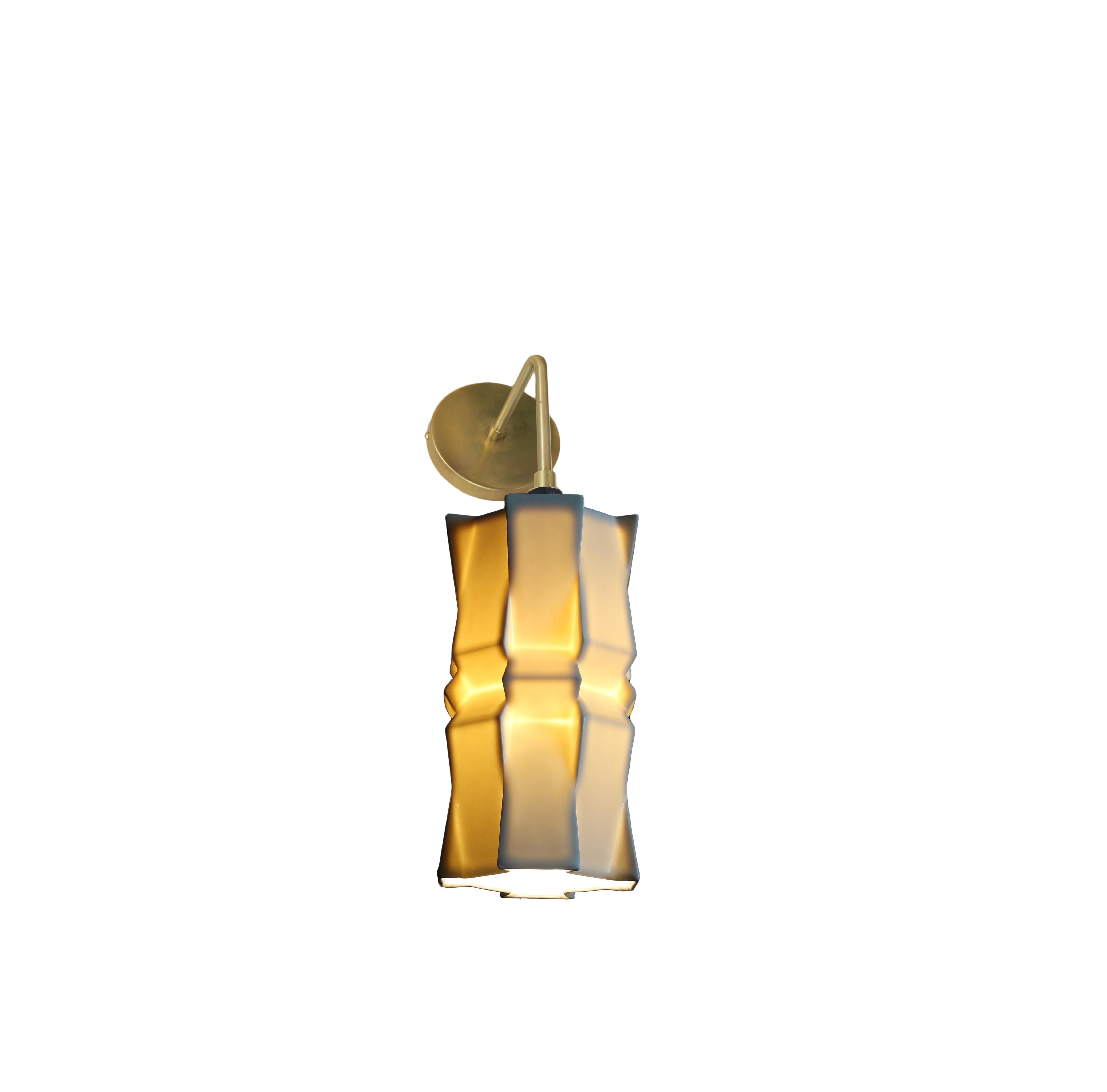 9 inch porcelain wall sconce the most intricate of the Tessellation collection, this porcelain wall sconce emits a soft, elegant glow through a striking geometric porcelain shade, shining direct downward or upward light through the open base. With